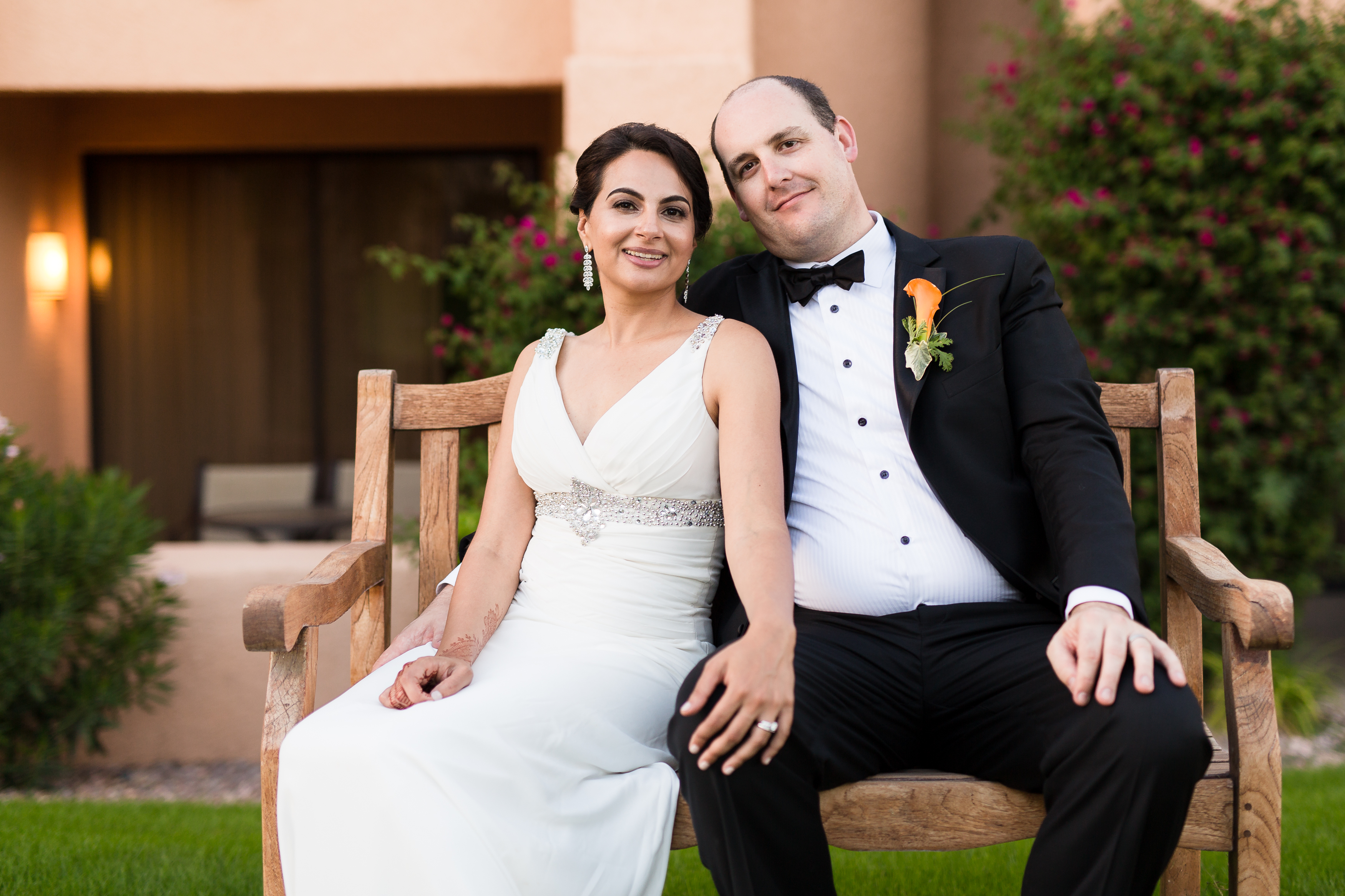 Bride and groom sitting on a wooden bench