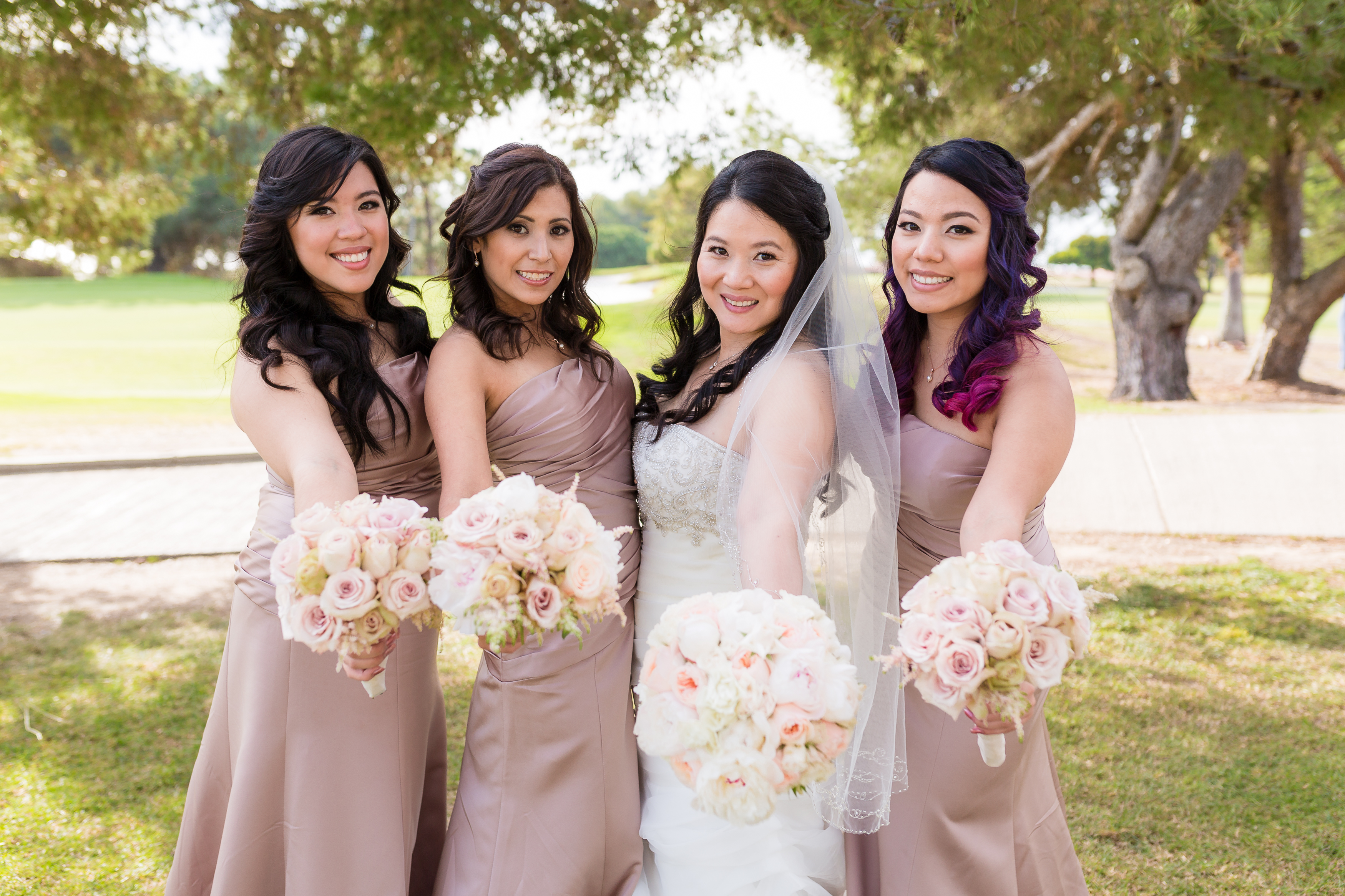 Bride with bridesmaids holding flower bouquets
