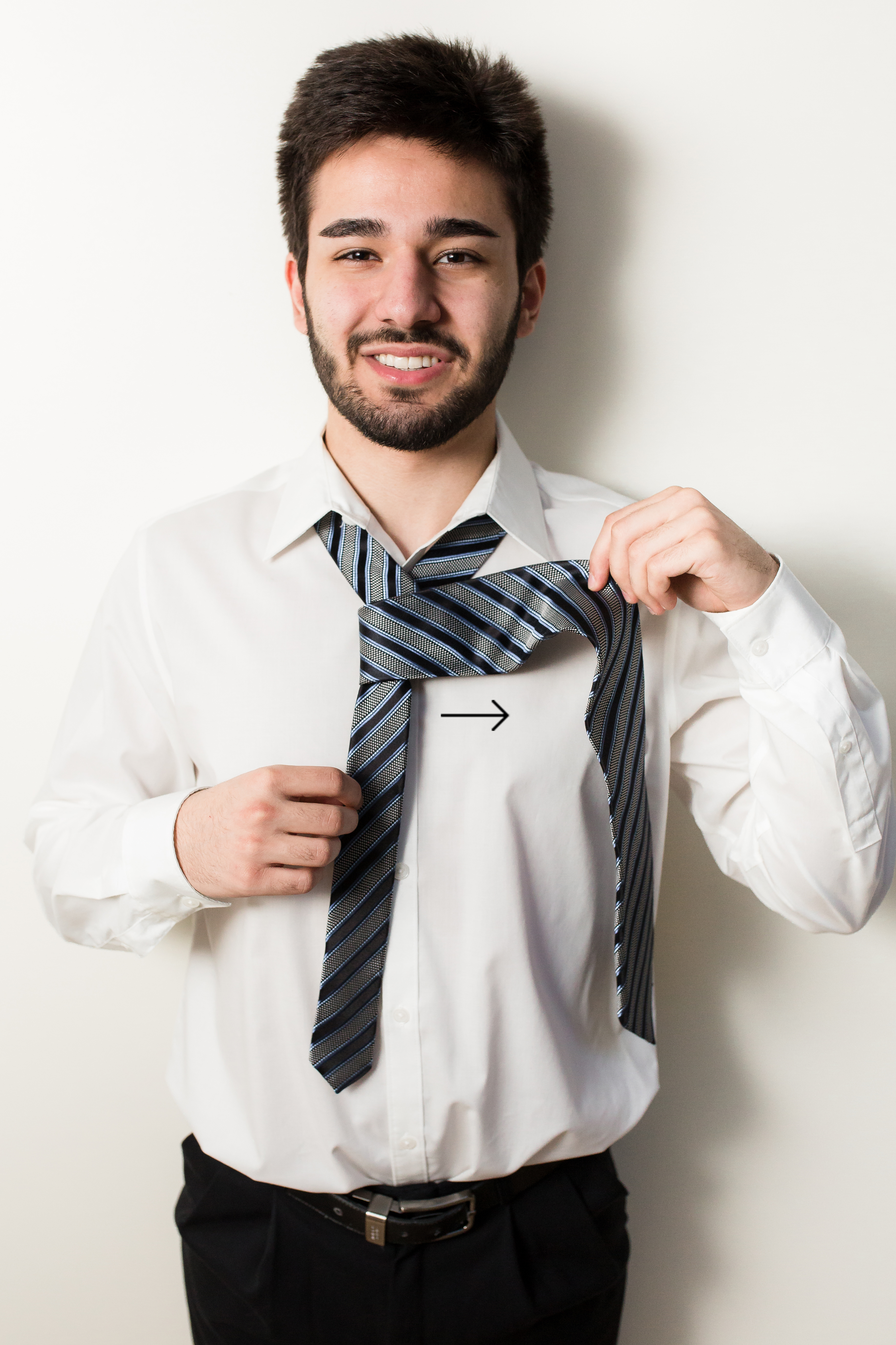 Groom shaping black and blue striped tie