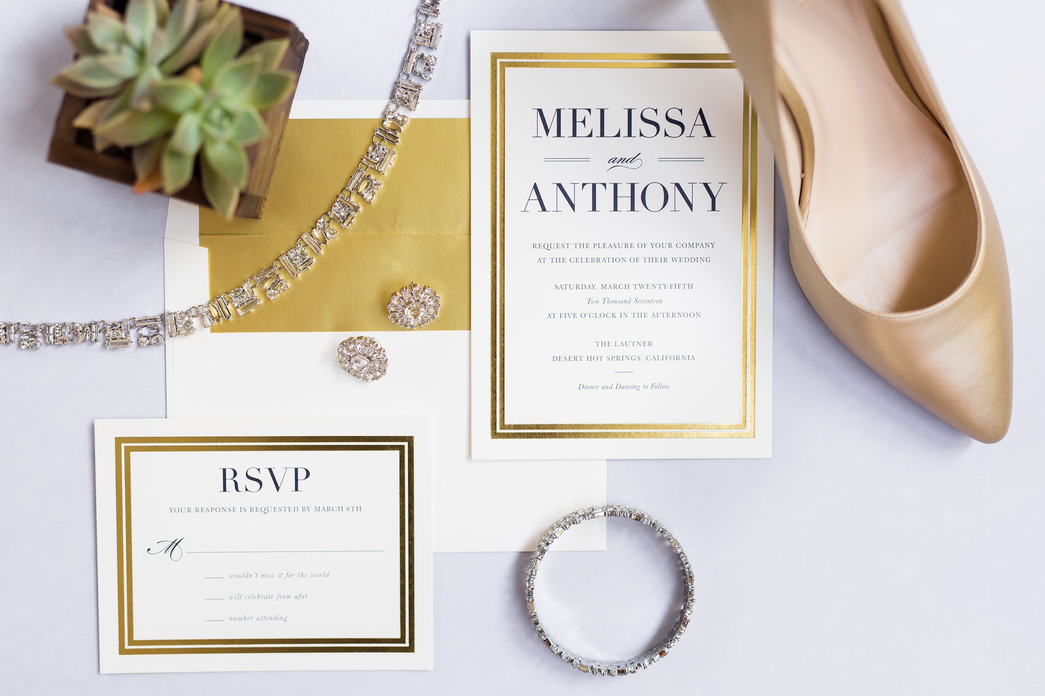 White and gold wedding invitation stationery with bride's diamond jewelry