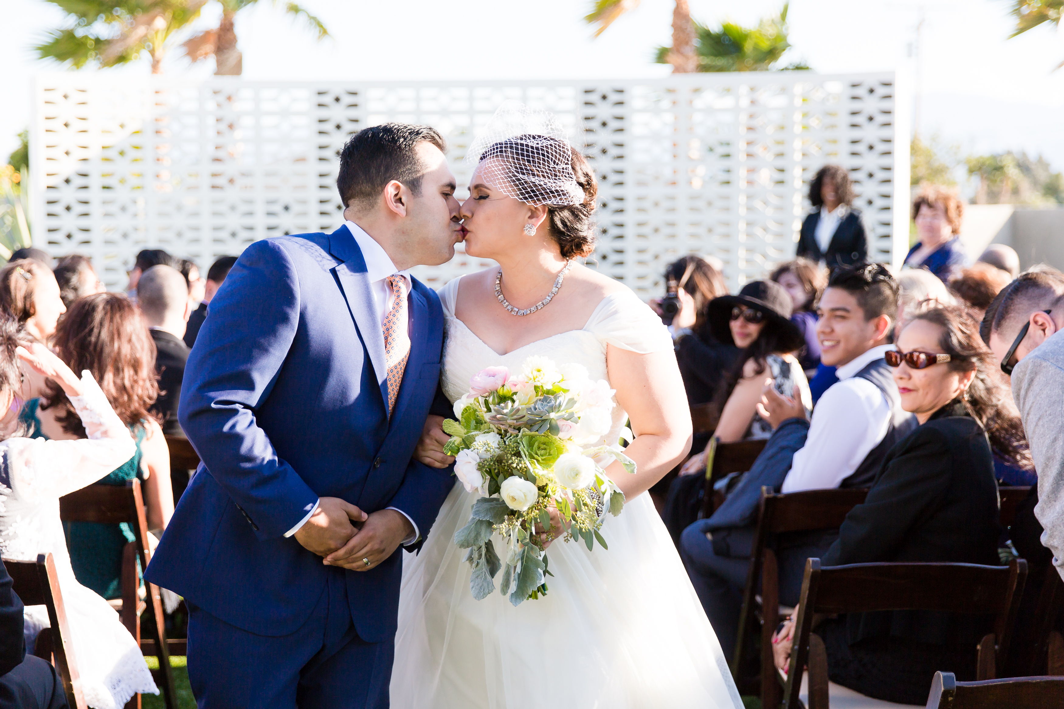Bride and groom first kiss during wedding ceremony, by Stefani Ciotti