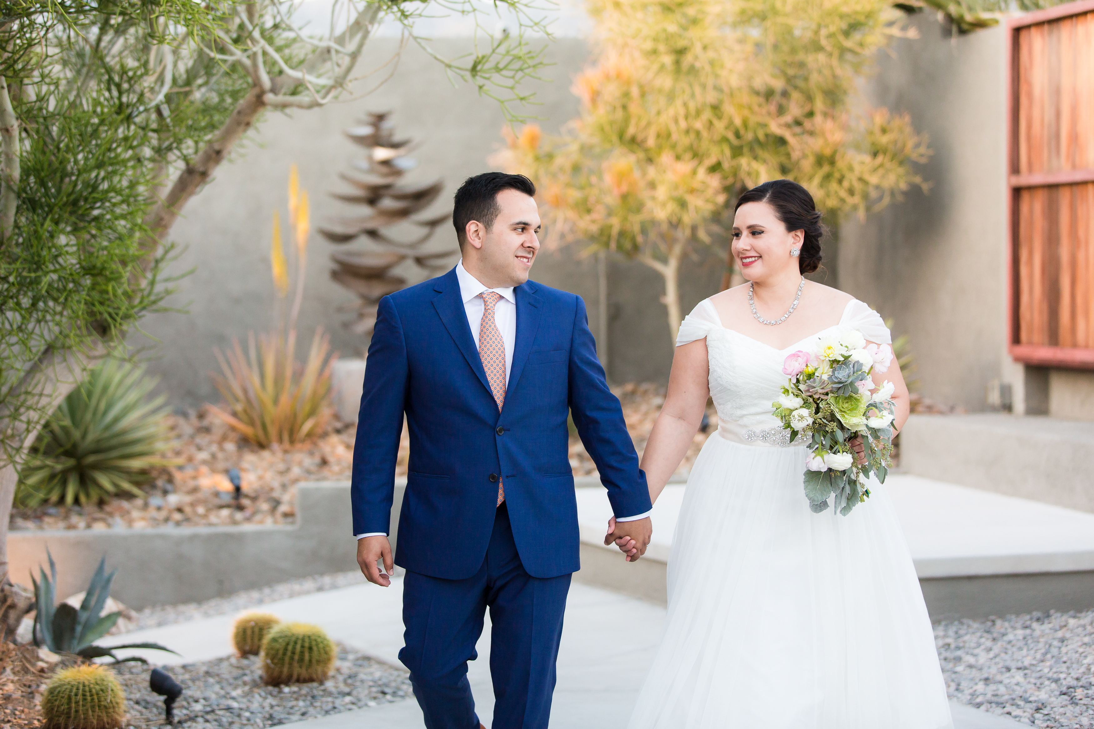 Bride and groom holding hands while looking at each other in Palm Springs