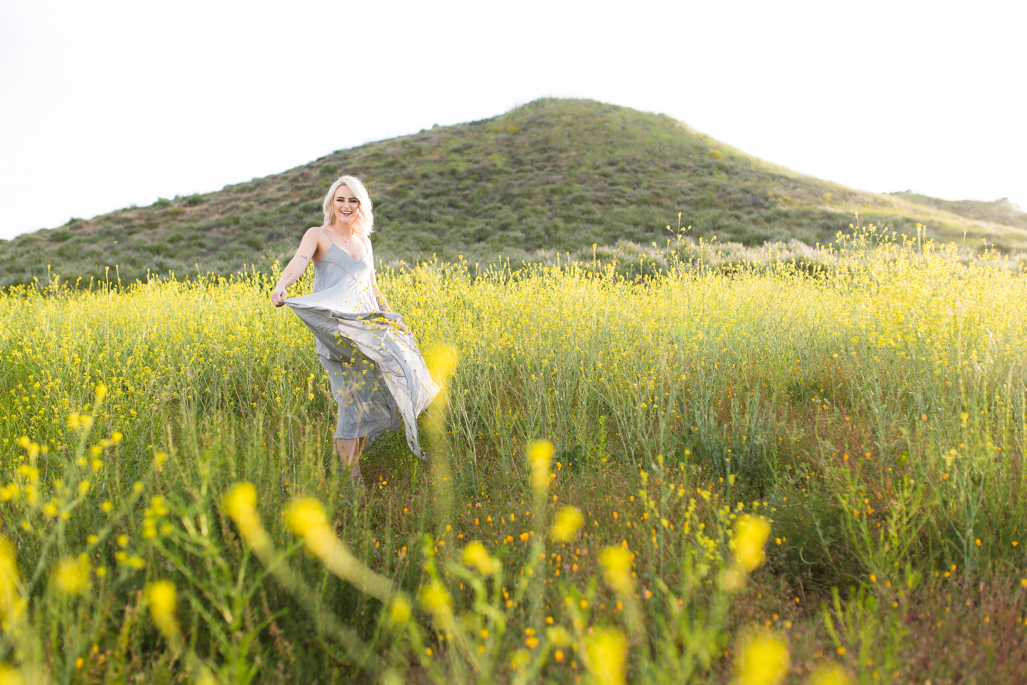 Beautiful model twirling dress in poppy field during this sunrise Portrait Session in Lake Elsinore