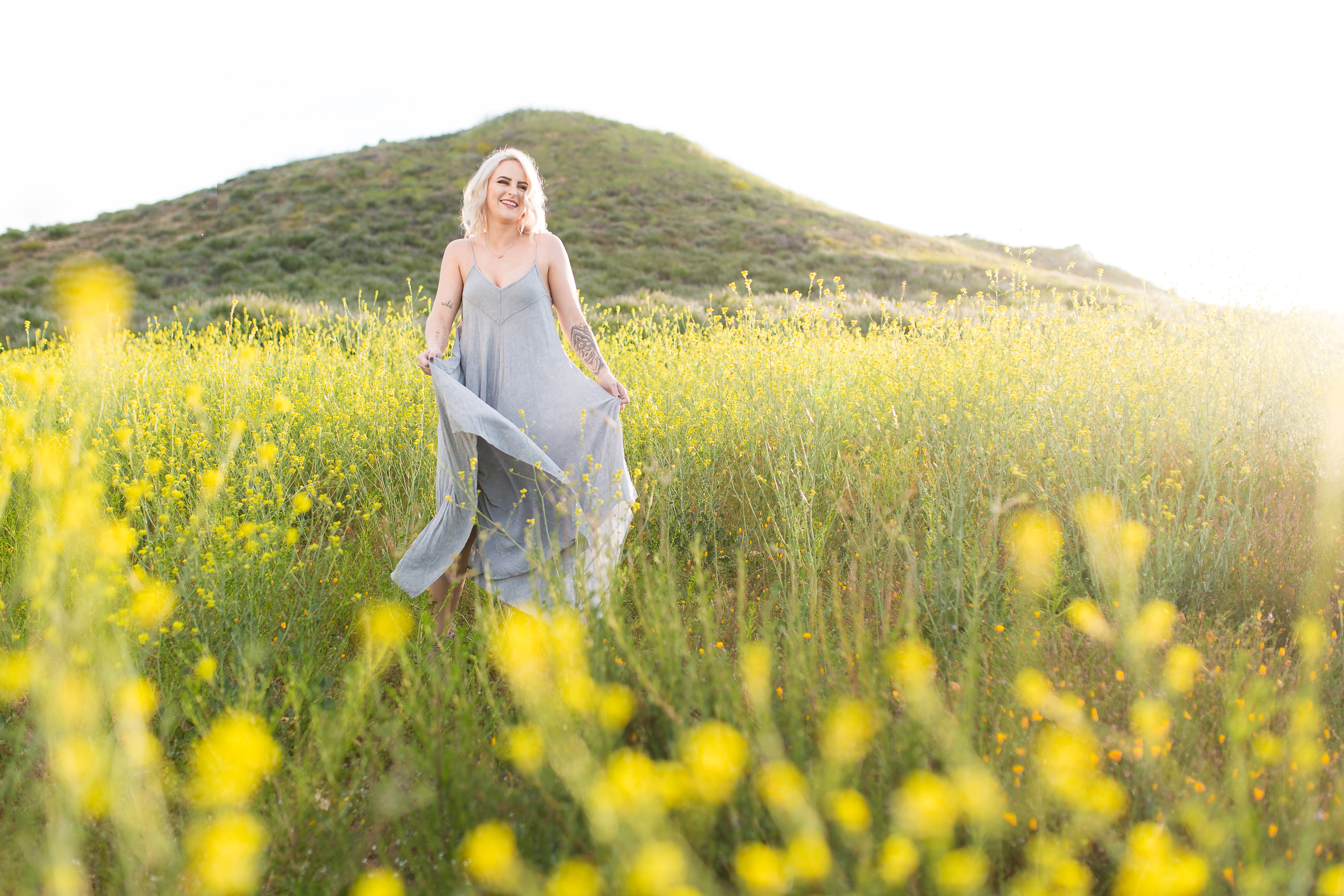 Model laughing and dancing in field of flowers at sunrise in CA
