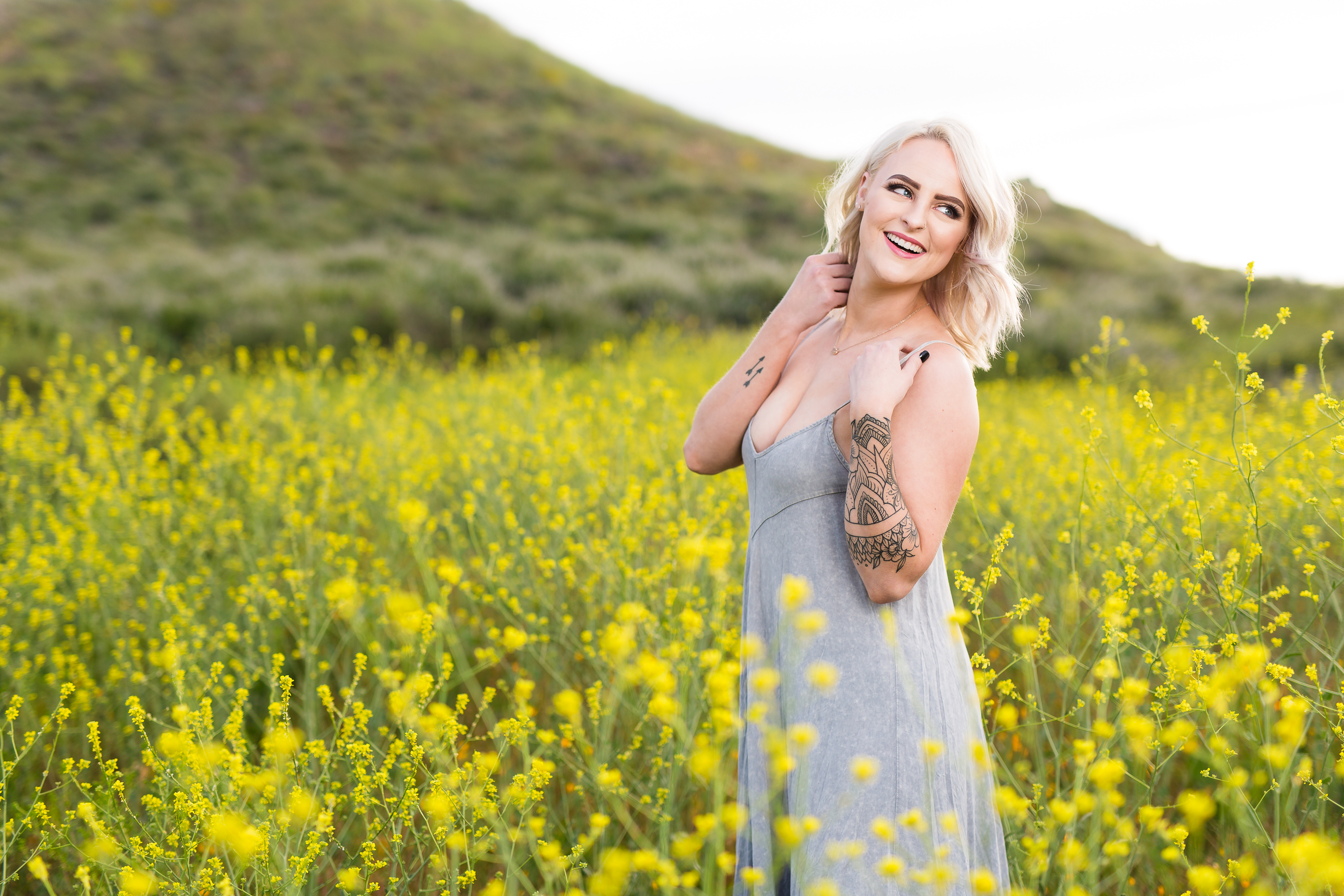 Woman laughing over shoulder in field of poppies in Lake Elsinore, by Stefani Ciotti