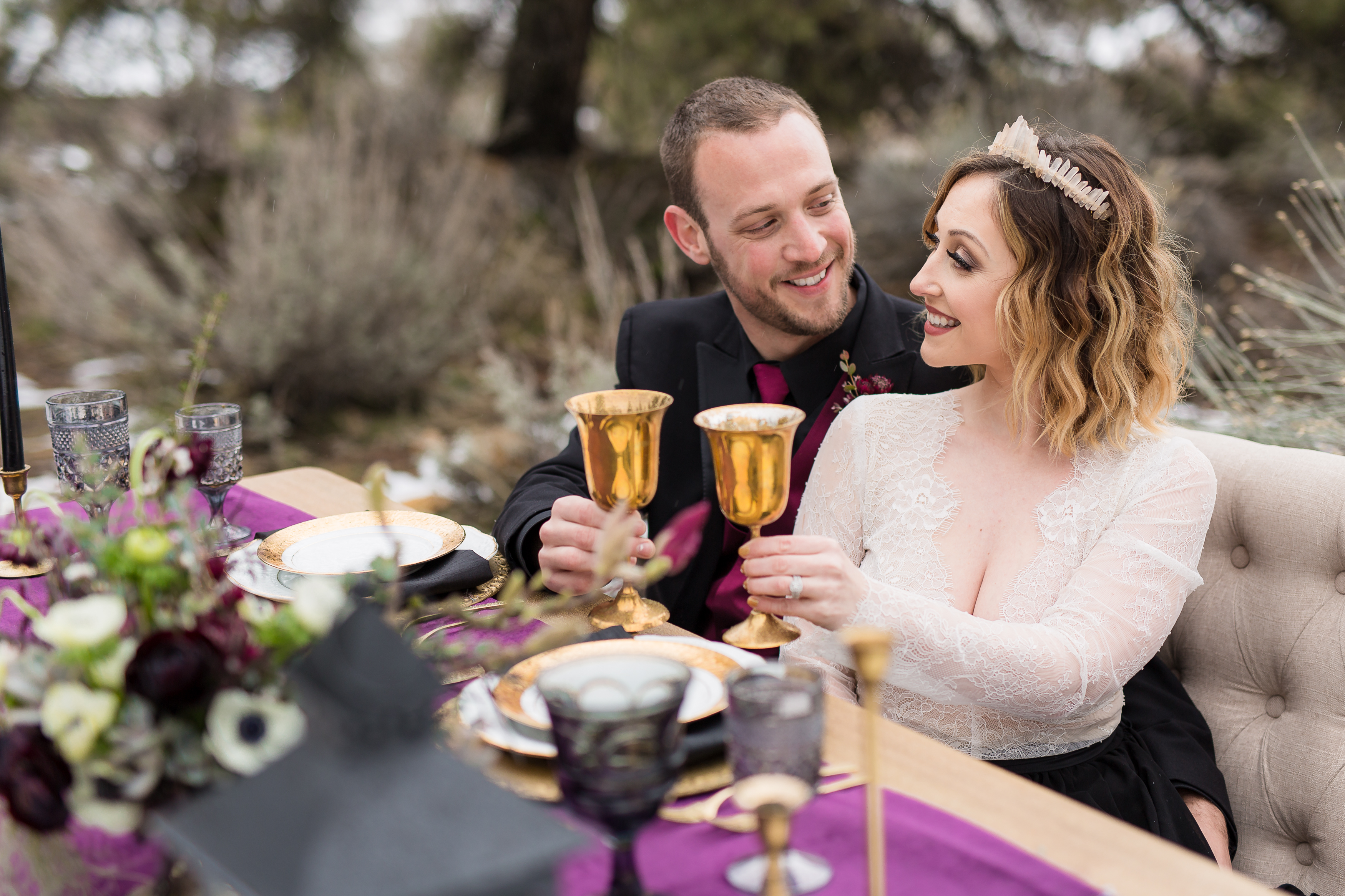 Man and woman toasting at sweetheart table with gold glasses