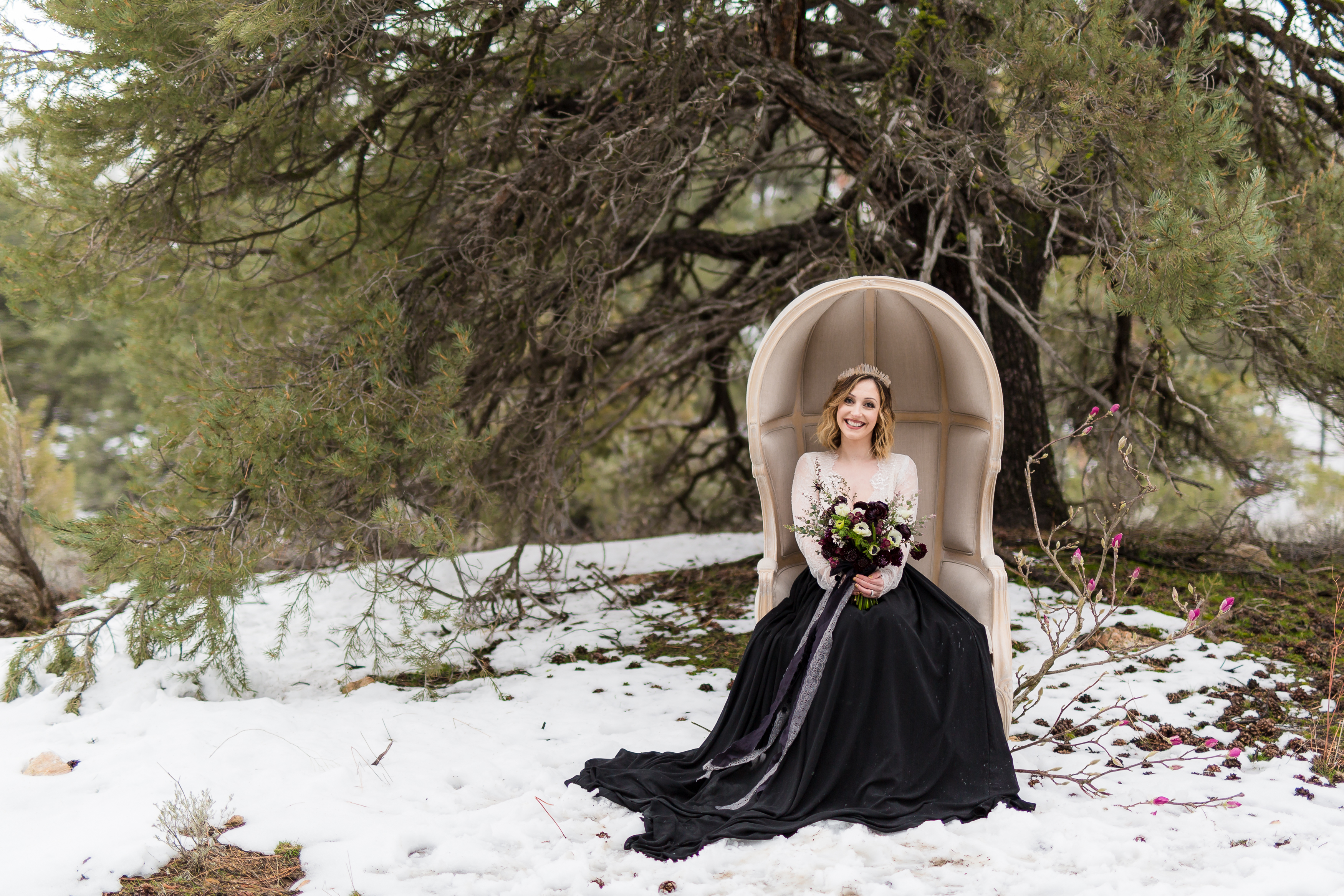 Bride in two piece wedding dress holding bold bridal bouquet in snow