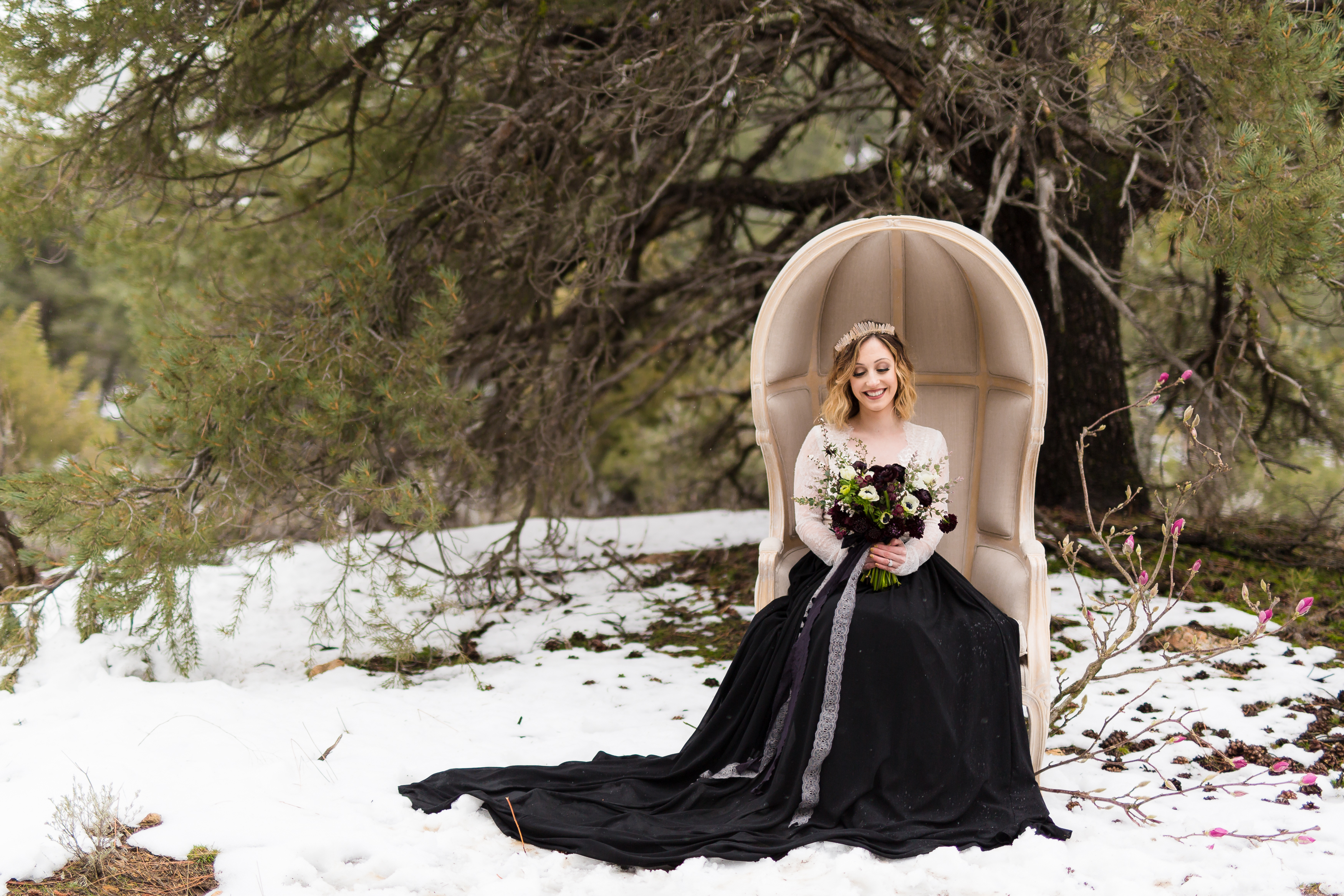 Bride in two piece wedding dress sitting in snow, photographed by Stefani Ciotti