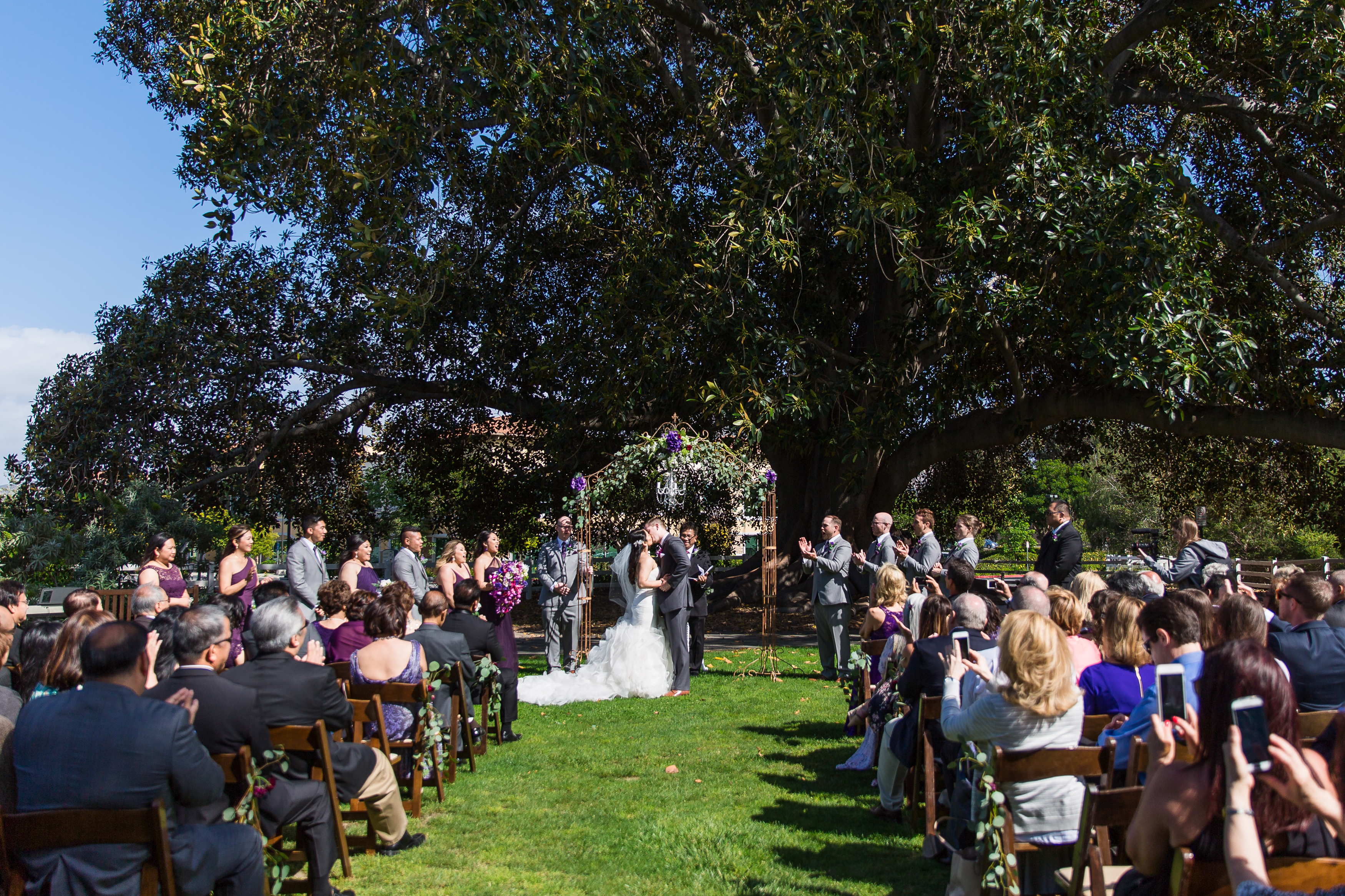 Couple's first kiss during outdoor ceremony at altar