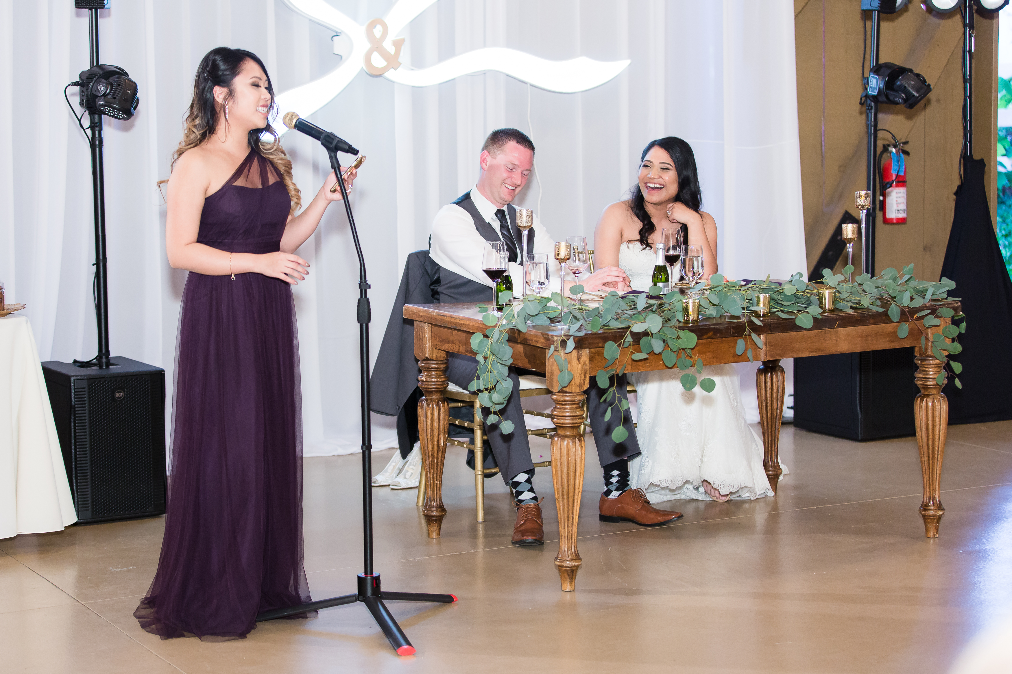 Wedding couple laughing at bridesmaid during toast