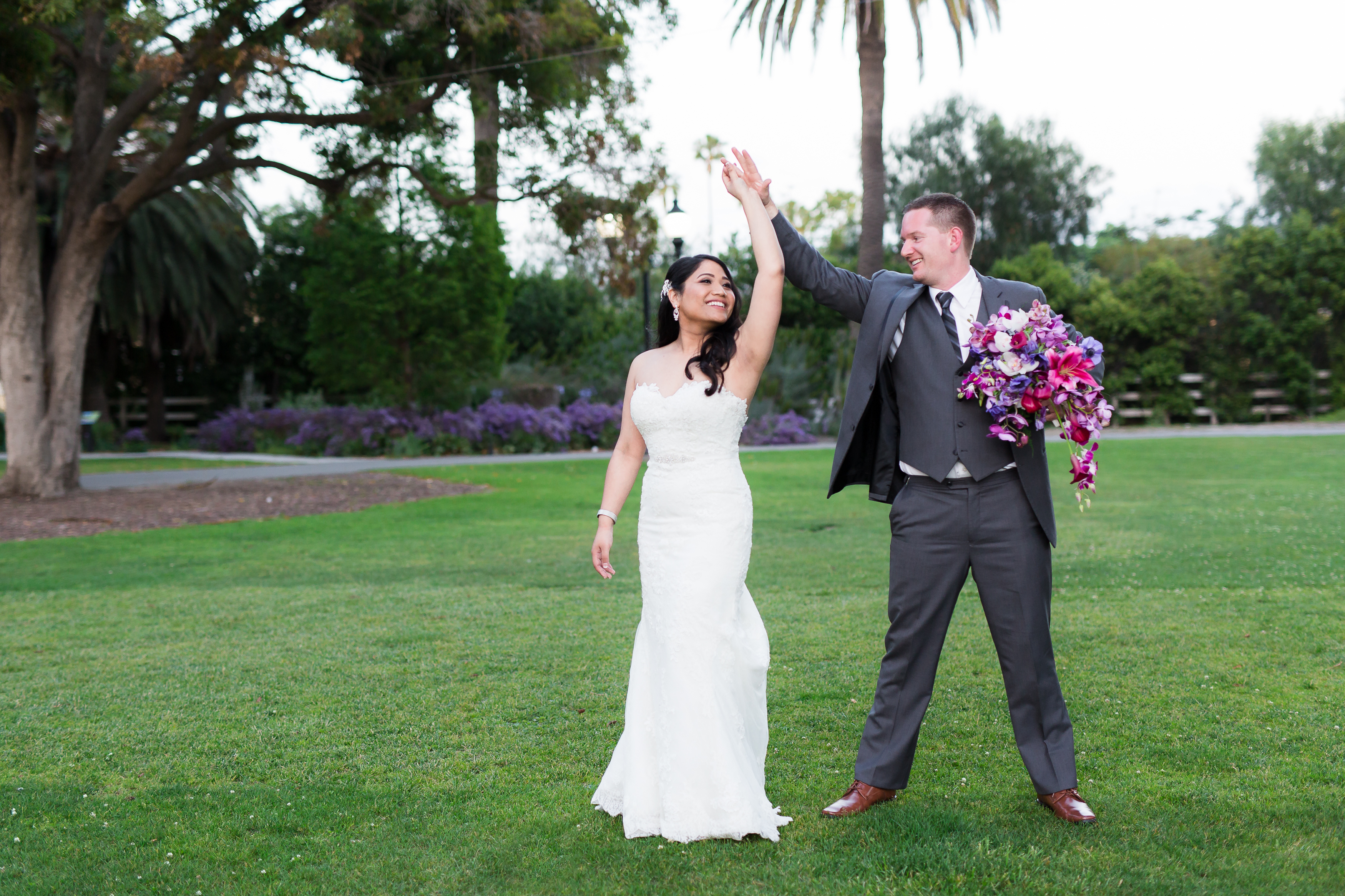 Bride and groom twirl and dance around lawn in California