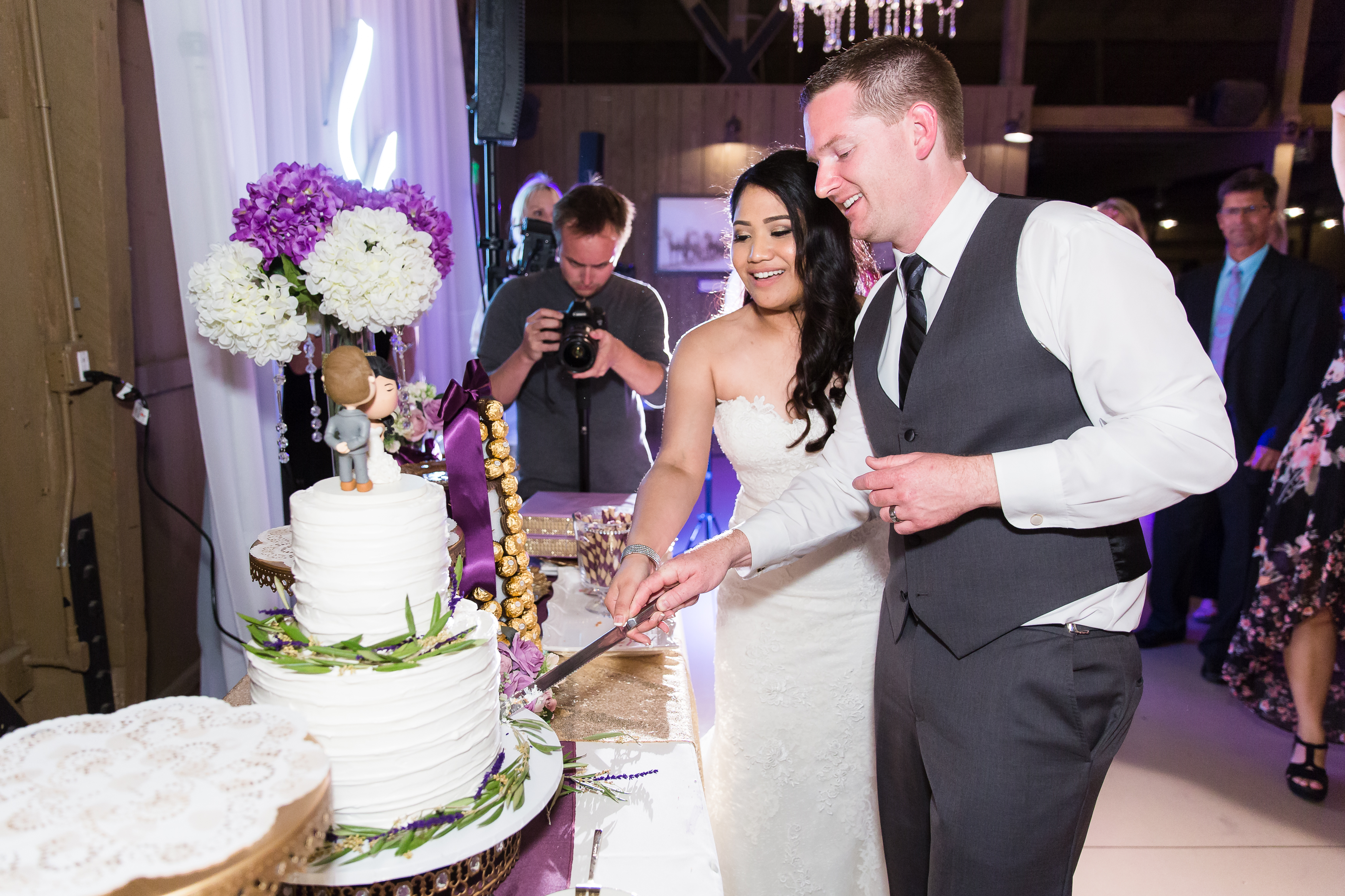 Bride and groom cut wedding cake during reception at Camarillo Ranch House