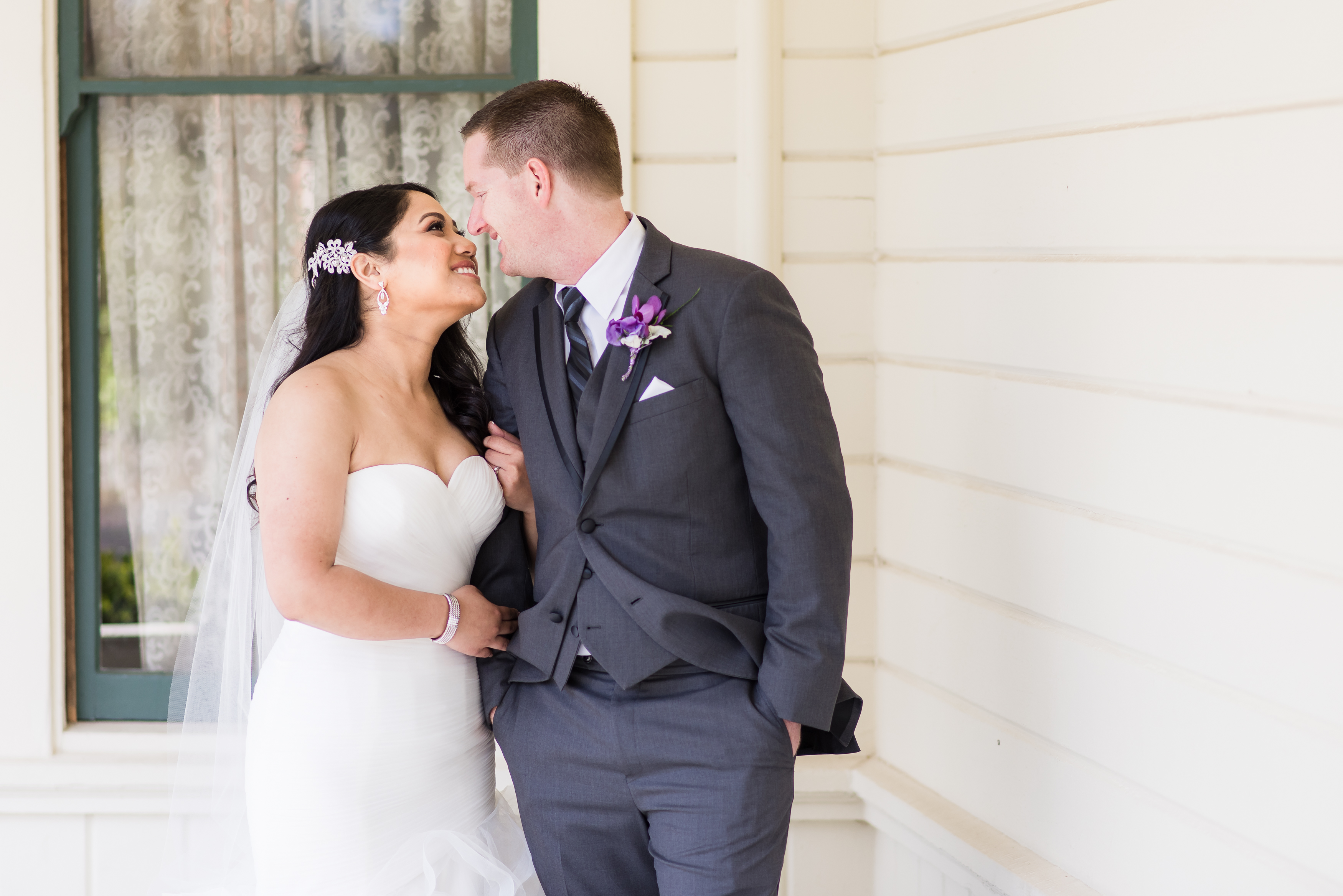 Beautiful bride kissing handsome husband by window