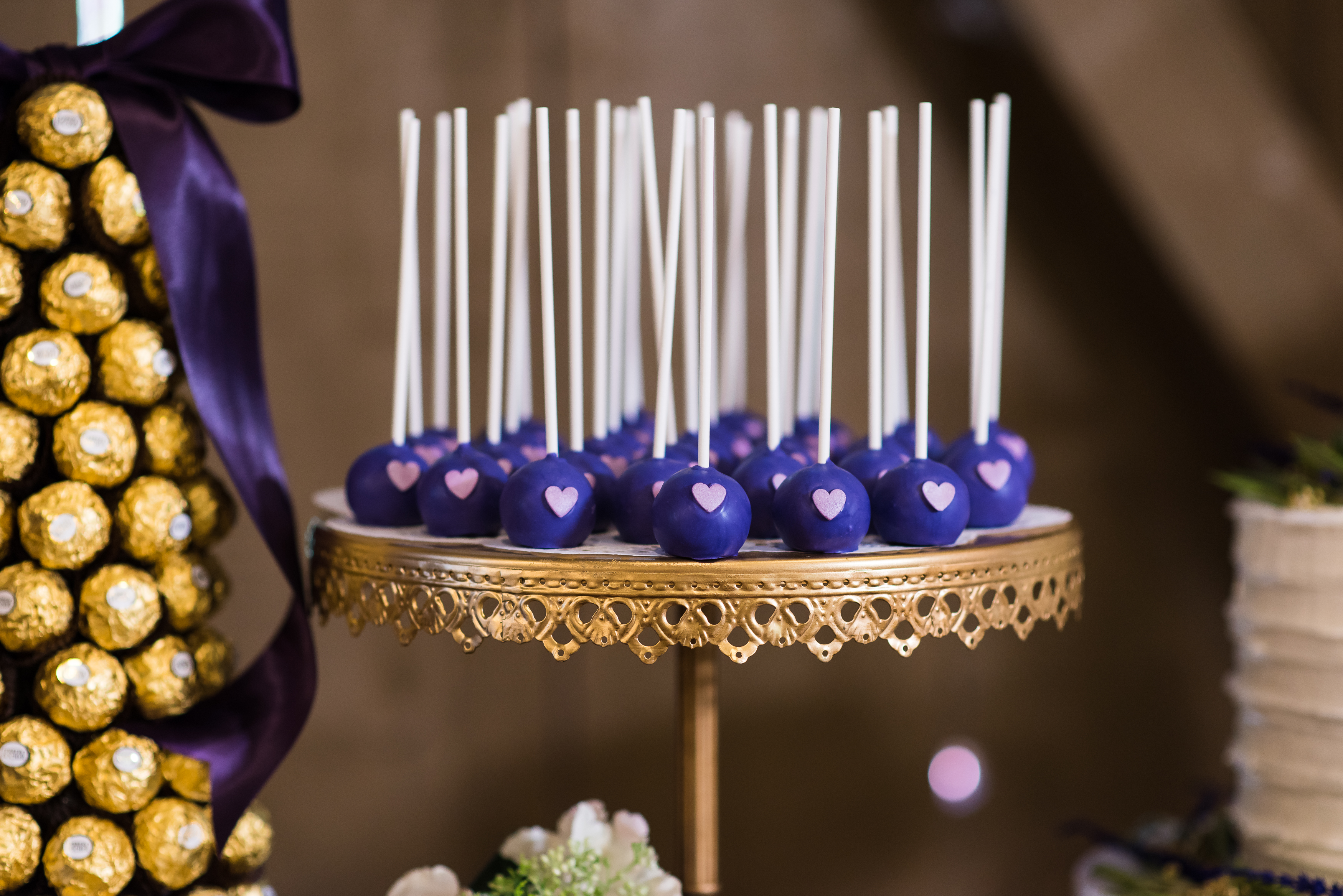 Purple cake pops with pink hearts on gold platter