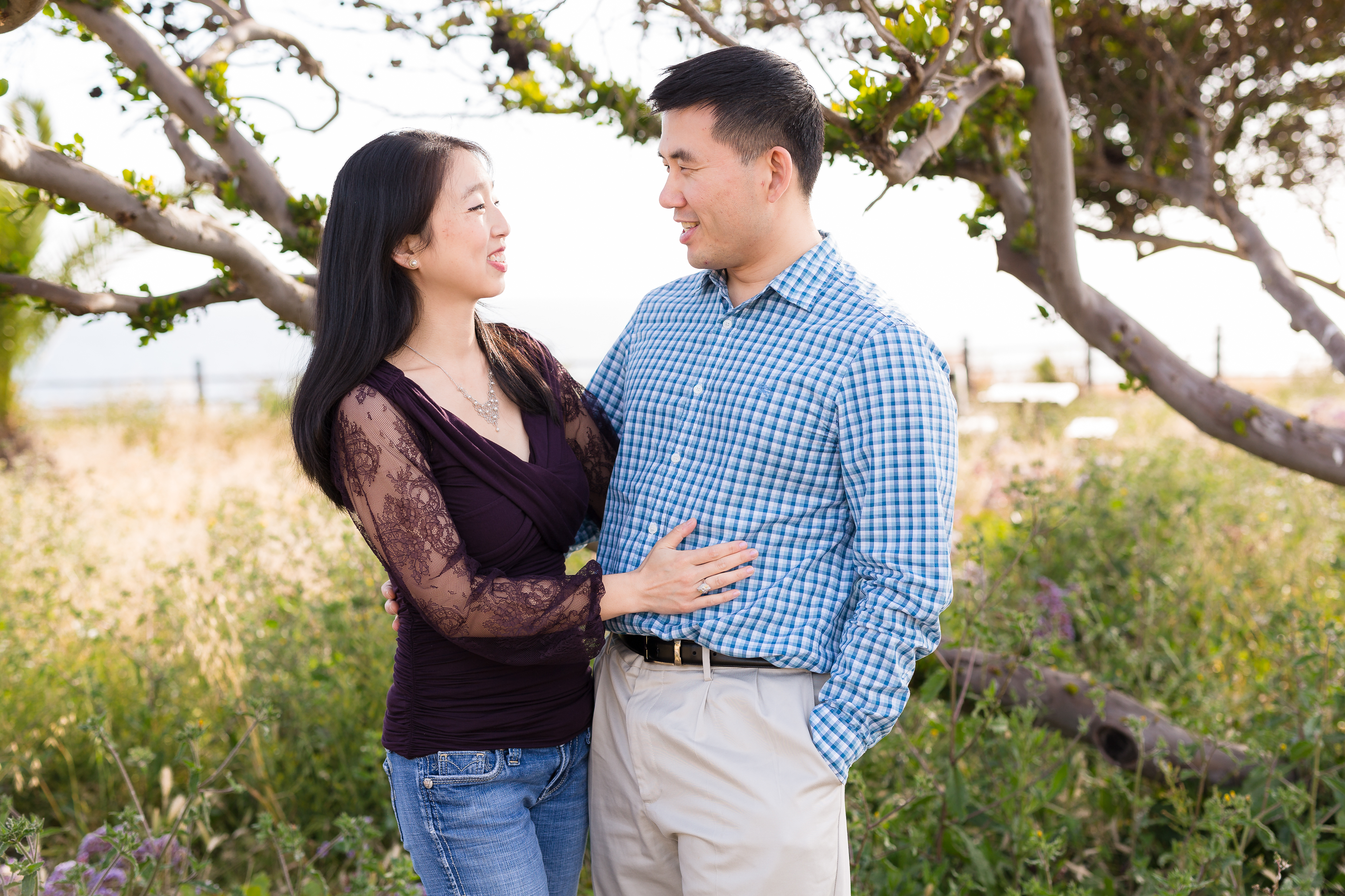 Sweet asian couple smiling at each other at engagement shoot