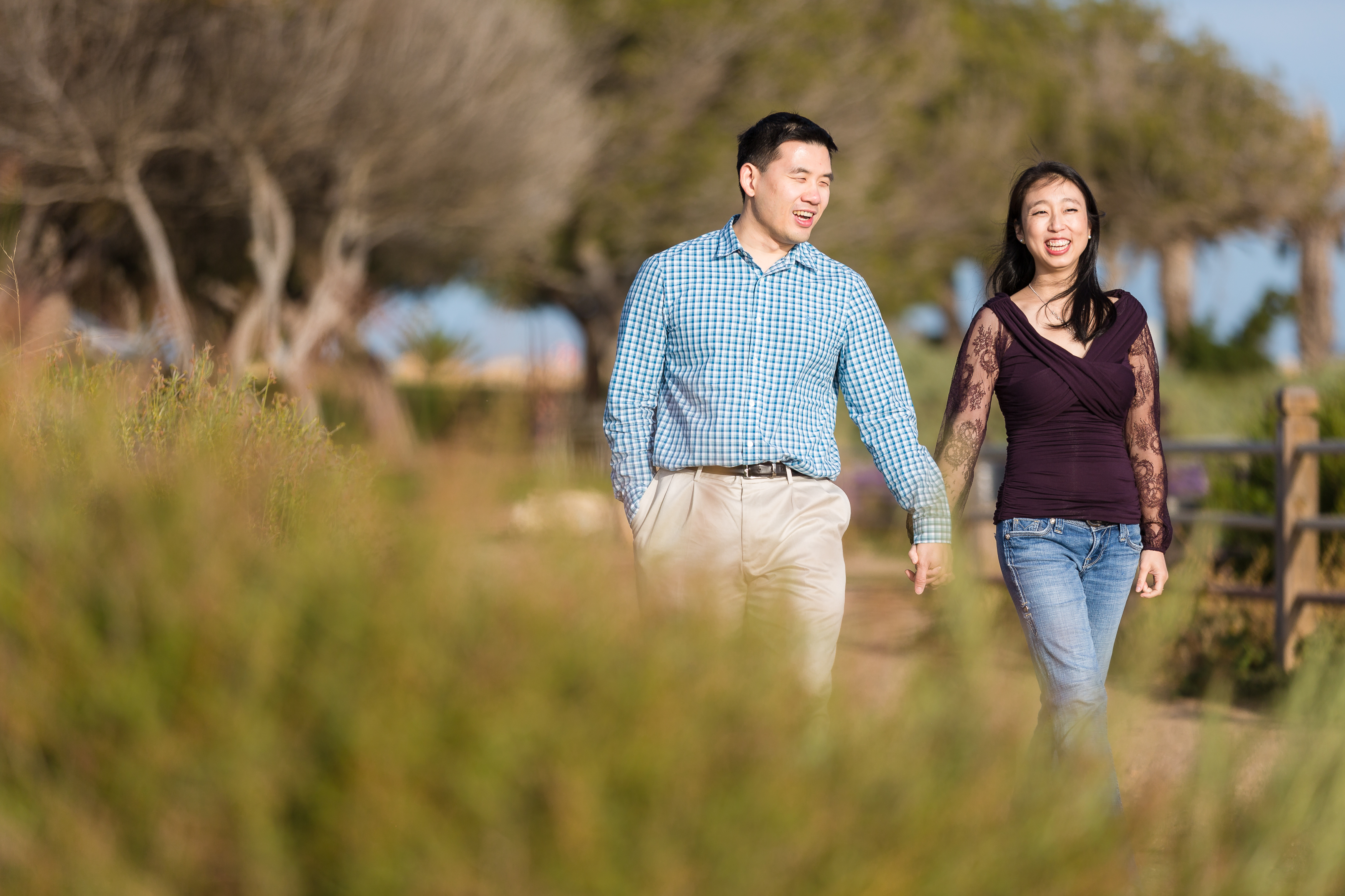 Asian couple strolling hand in hand and laughing