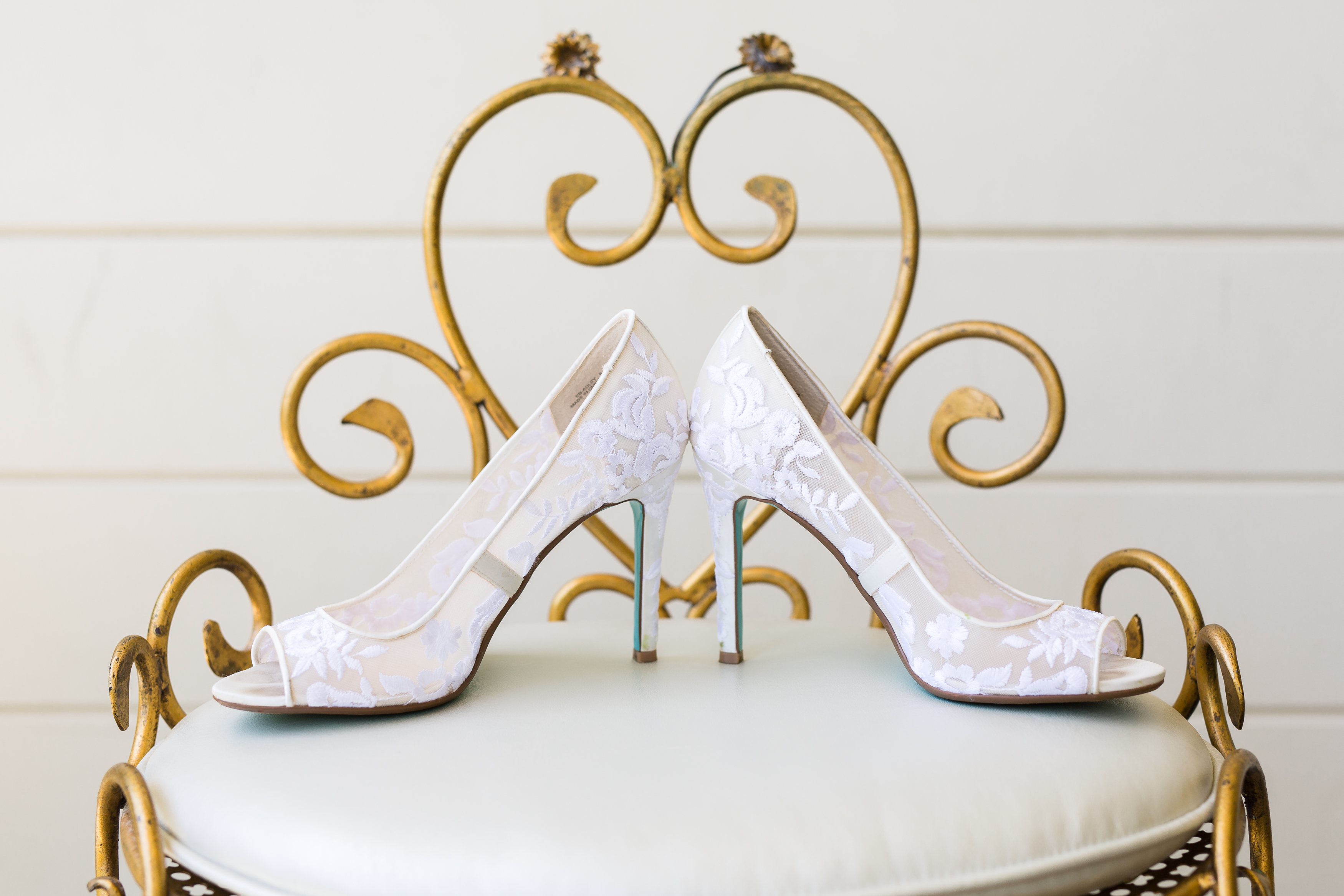 White bridal wedding shoes on golden stool