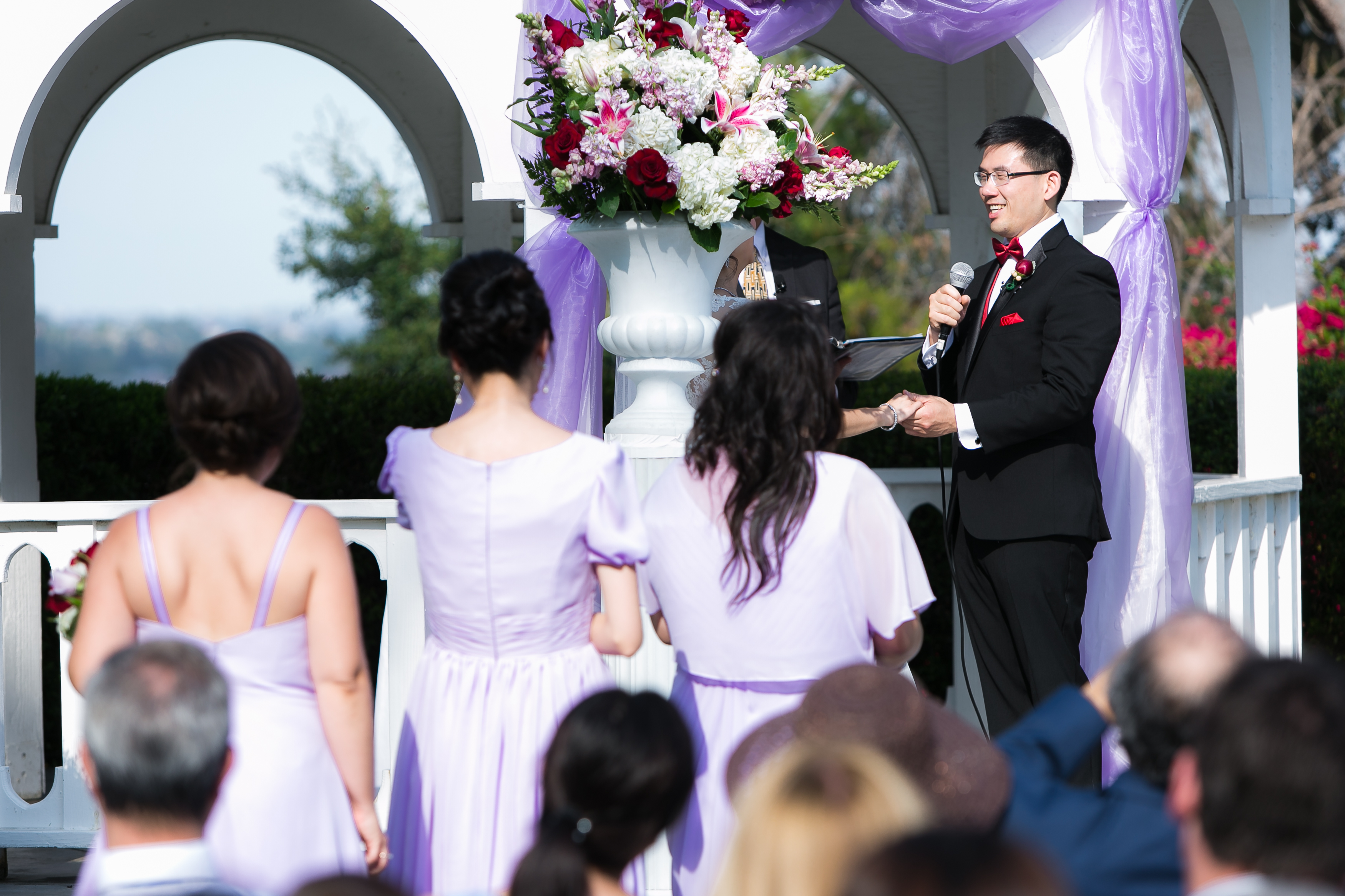 Groom laughing at bride during wedding ceremony in gazebo