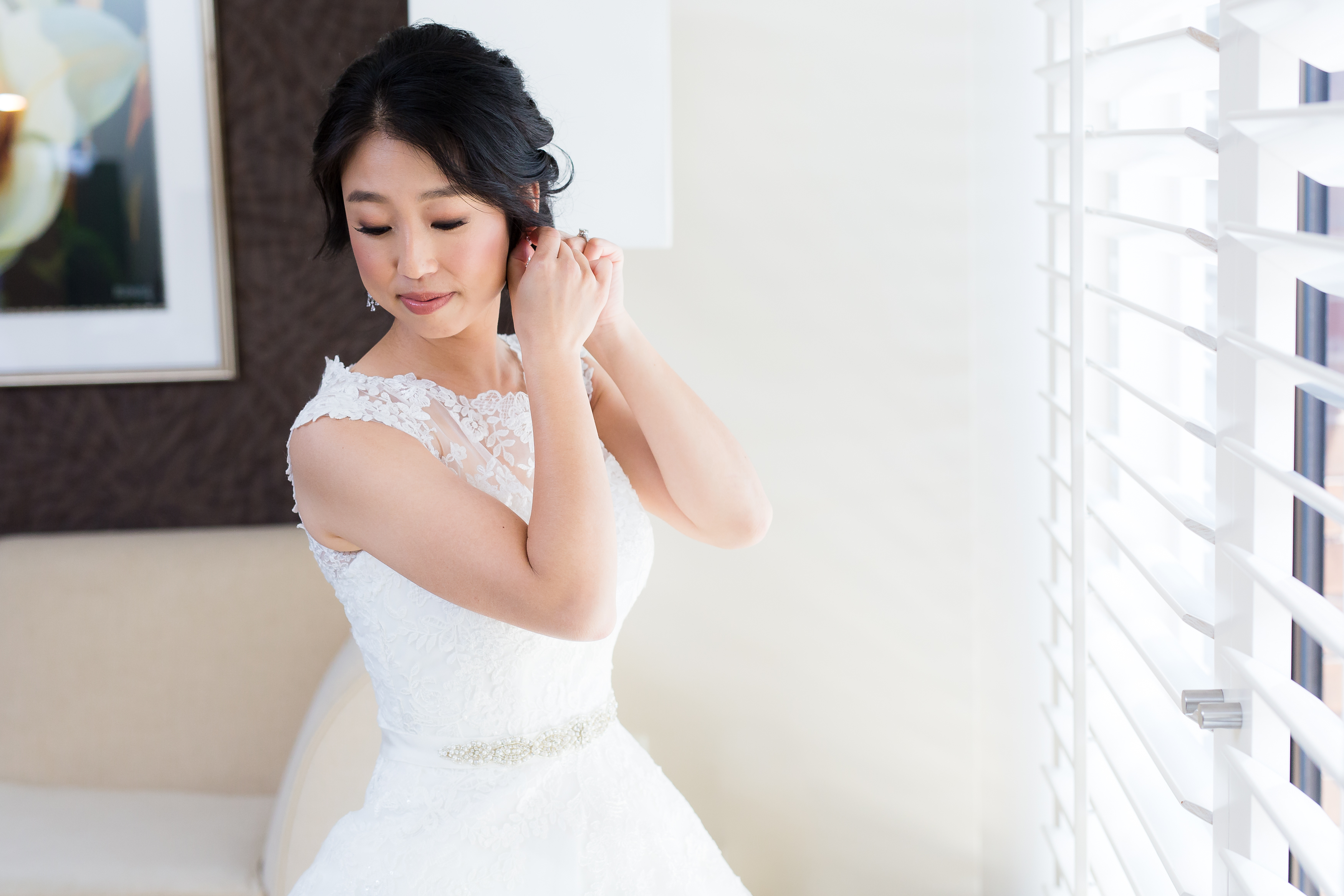 Beautiful woman in wedding dress adjusting earring