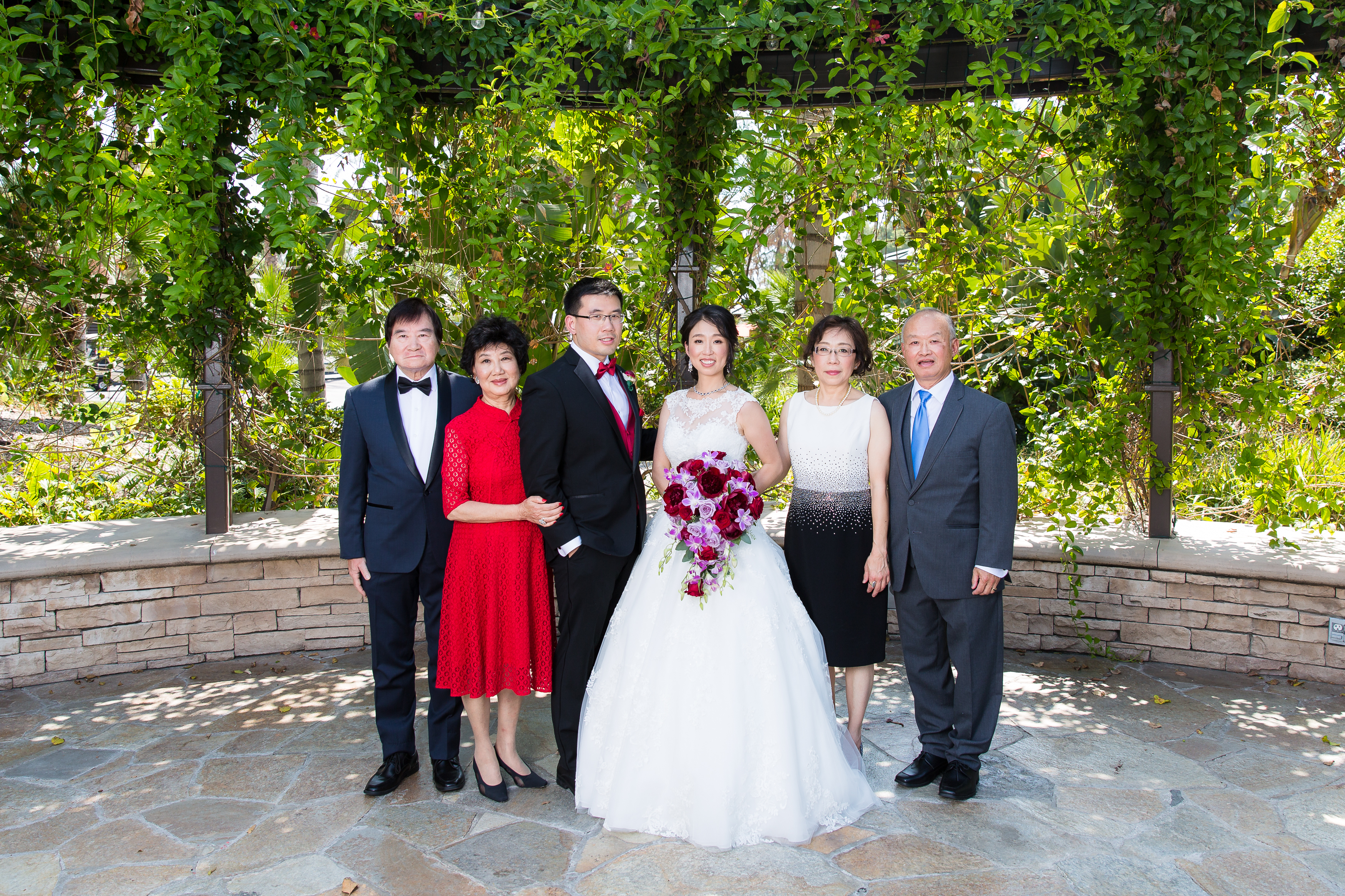 Bride and groom's family standing next to couple at Pacific Palms Resort Wedding