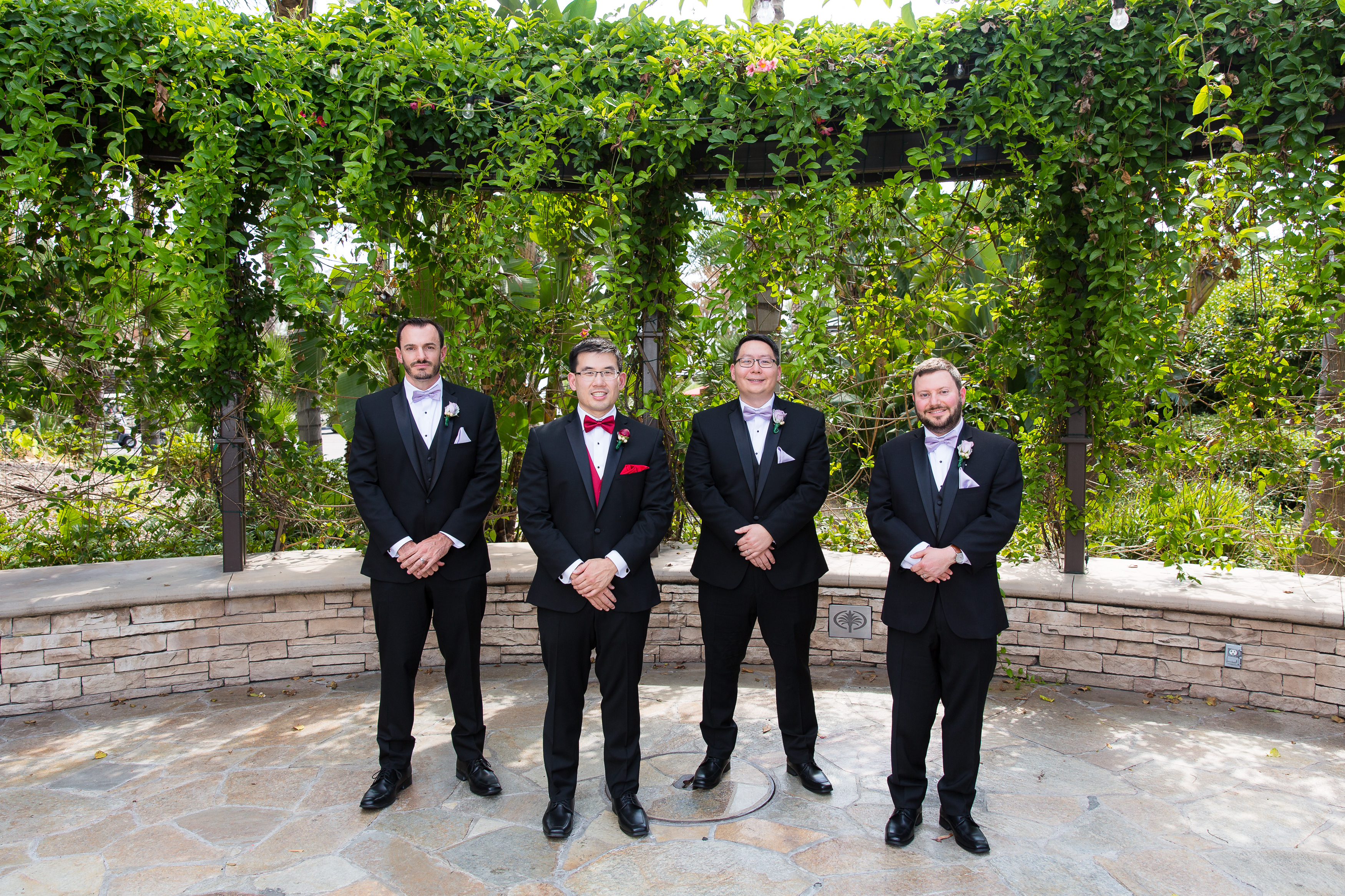 Groom smiling with groomsmen in black tuxedos