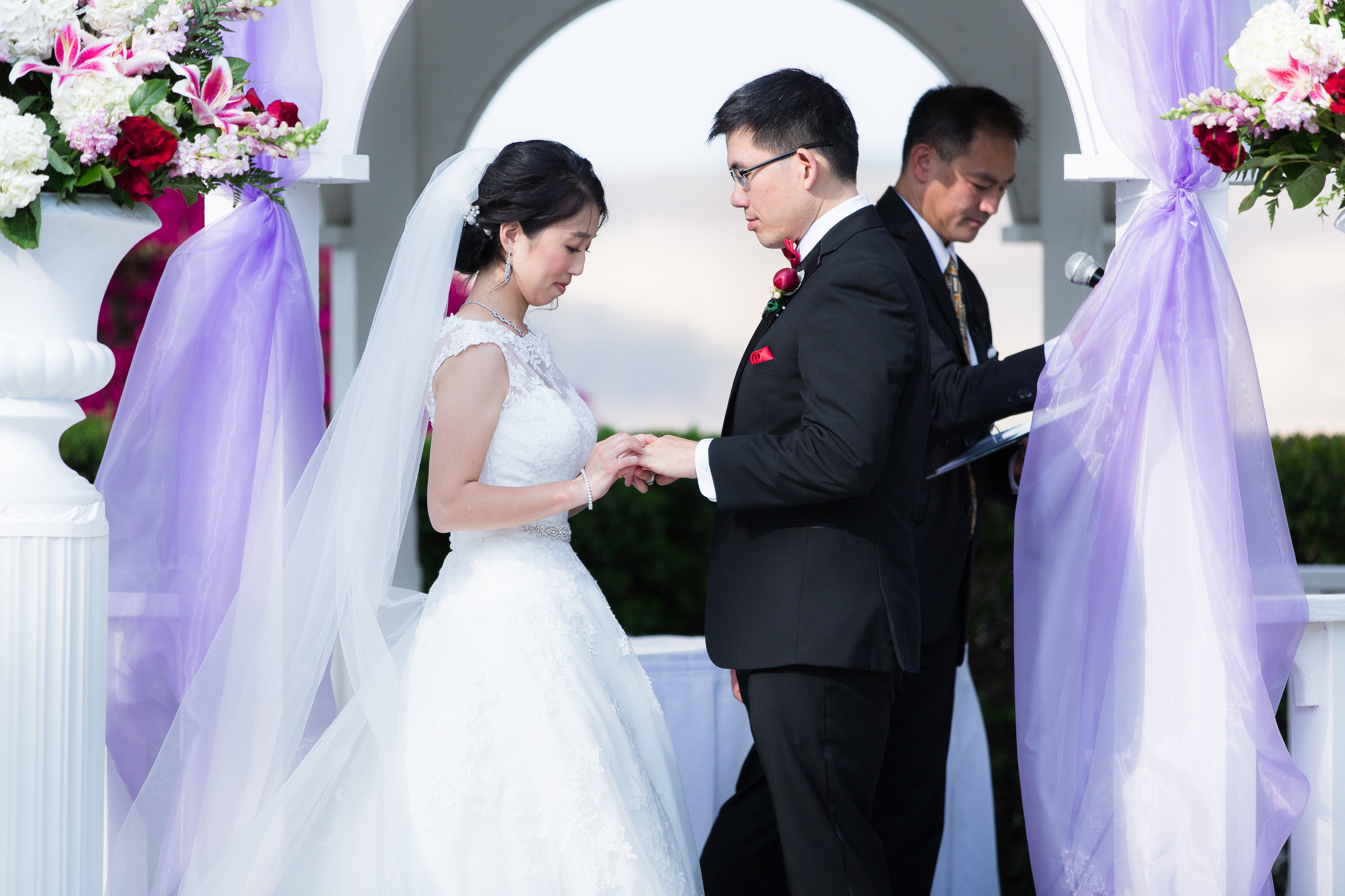 Bride putting ring on groom during wedding ceremony