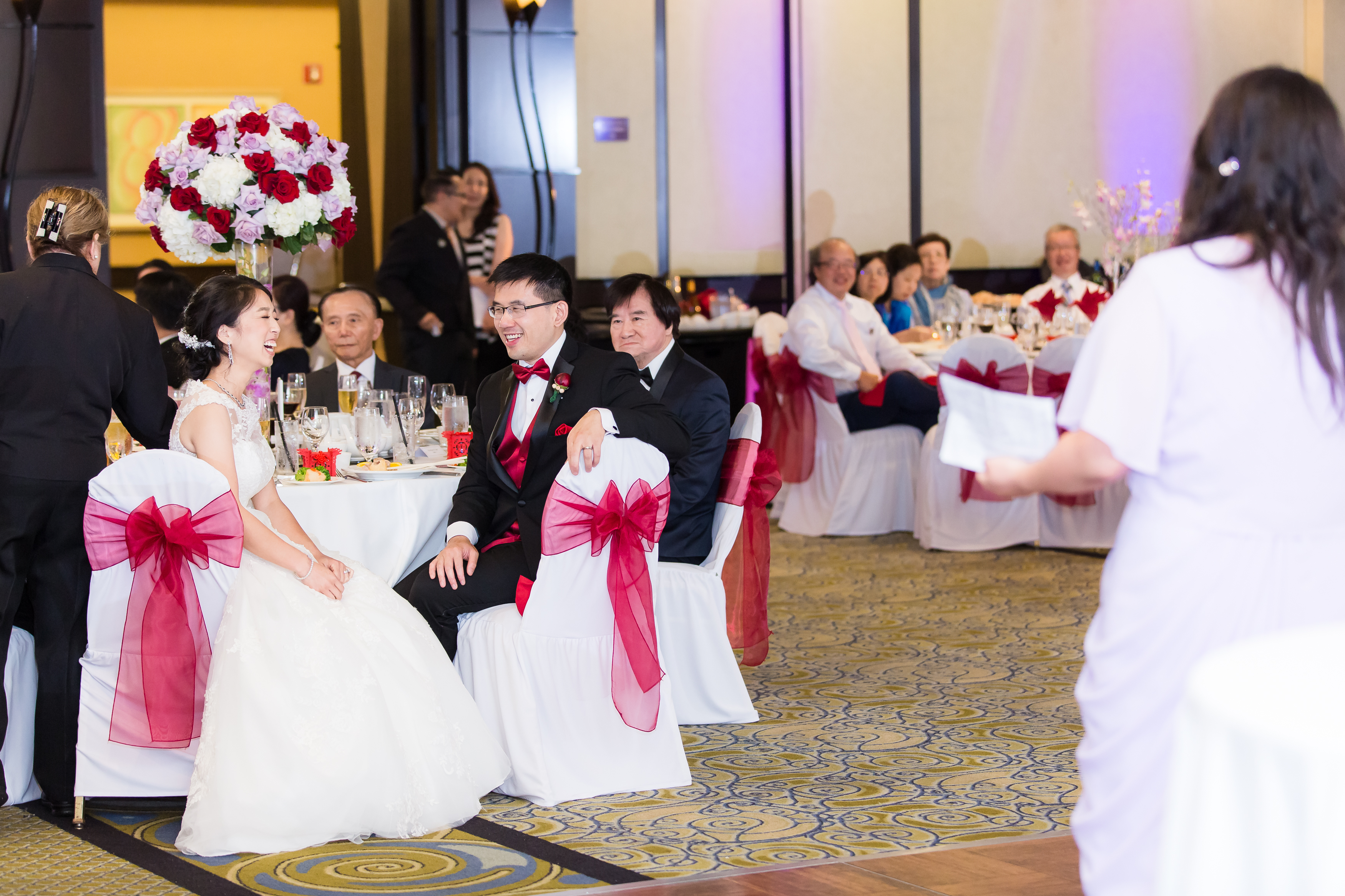 Couple laughing at sweethearts table during wedding reception