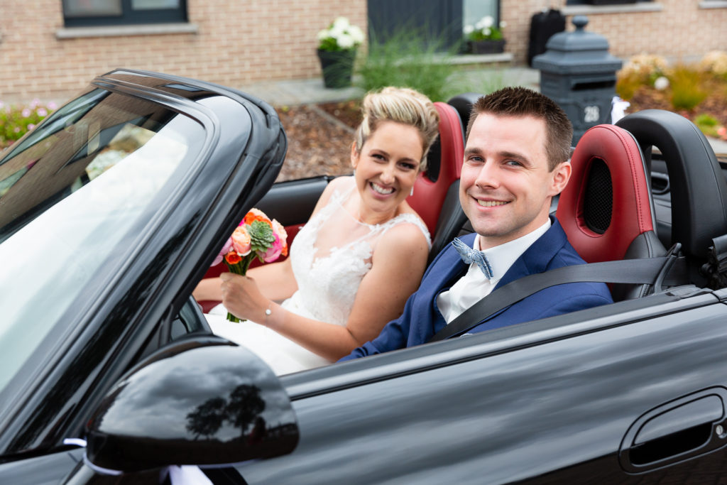  bride and groom in sports car