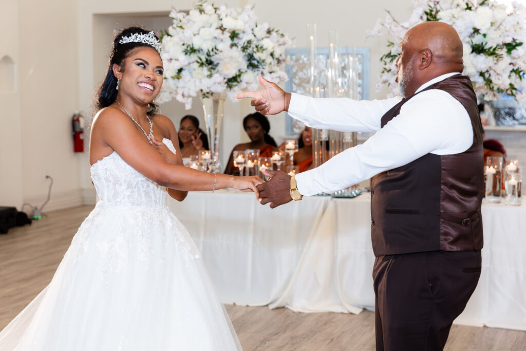 dad pointing at bride smiling and dancing during parent dance at knotting hill place wedding venue