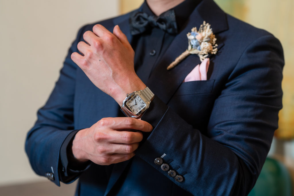 Dallas photographer captures groom adjusting his suit on his wedding day 