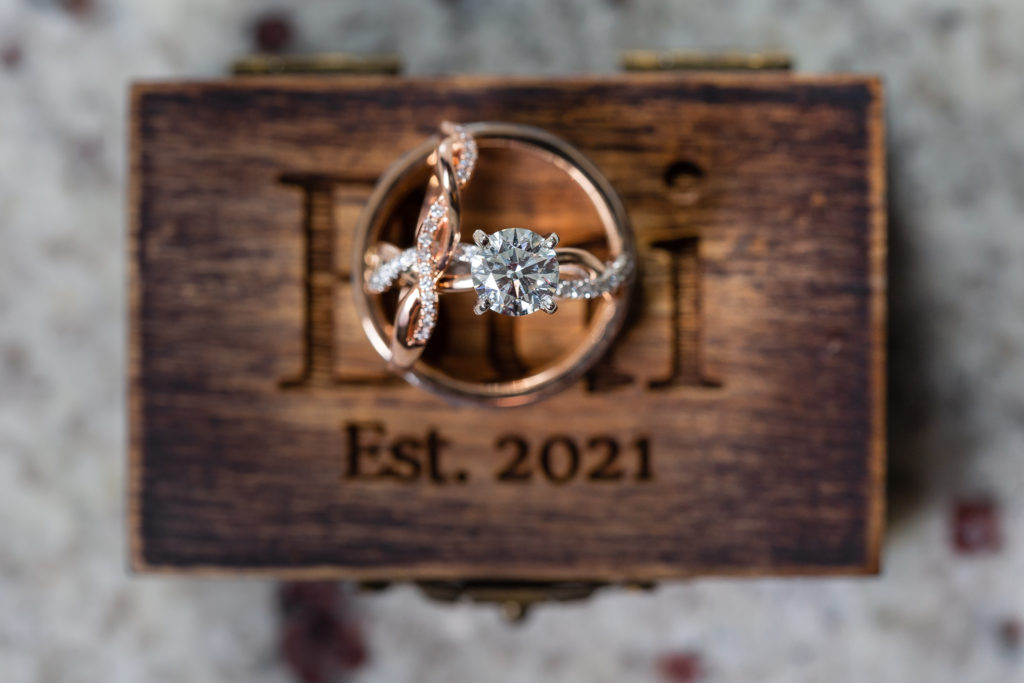 Silver and gold engagement and wedding band on wooden box