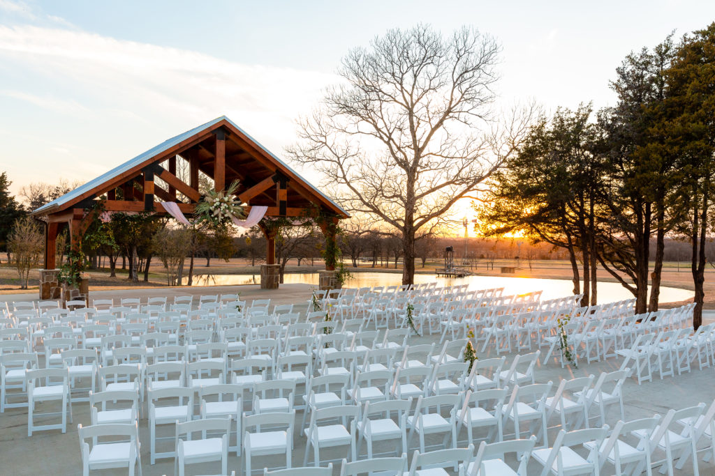 Boyd Farm's outdoor ceremony site overlooking a lake at sunset in Dallas TX