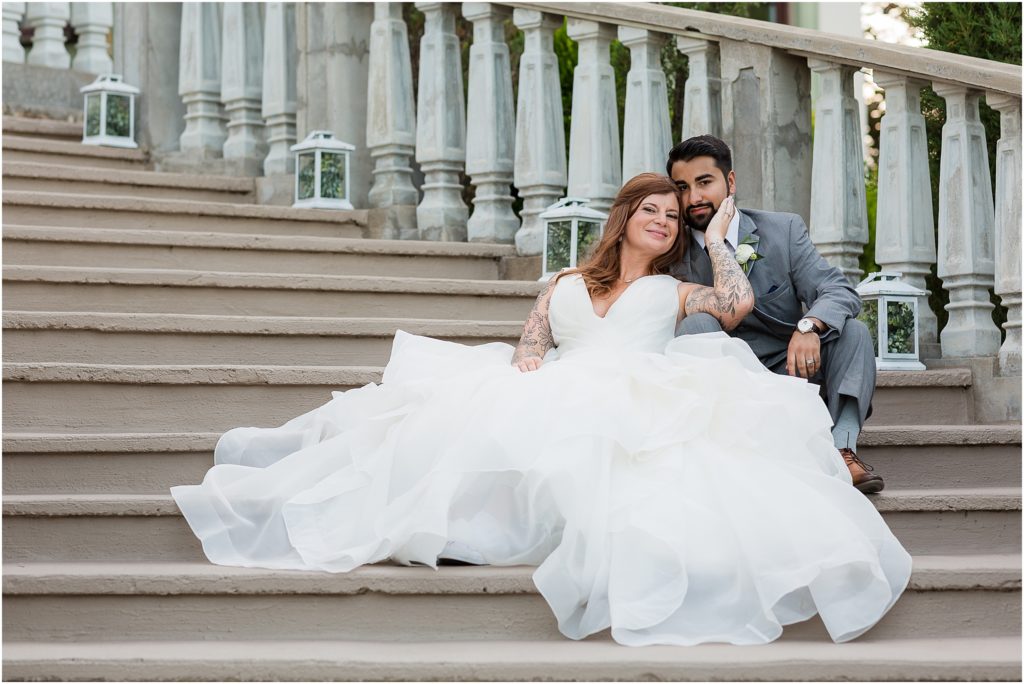 elegant portrait of bride and groom sitting on staircase in wedding attire at stoney ridge captured by Dallas wedding photographers