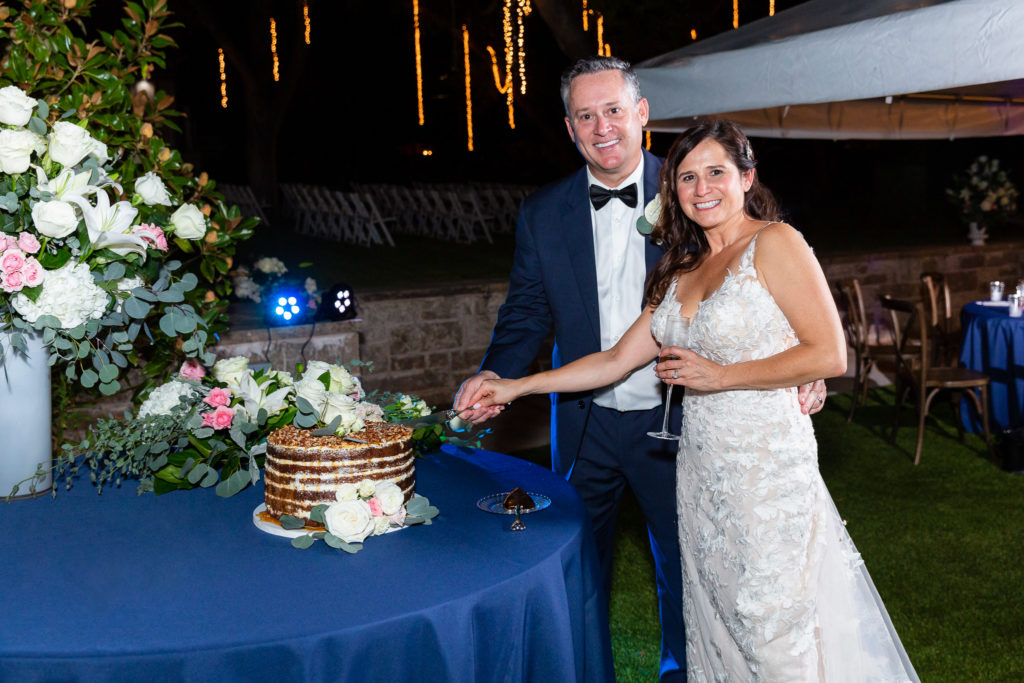 Granbury wedding with bride and groom holding a knife together to cut their wedding cake