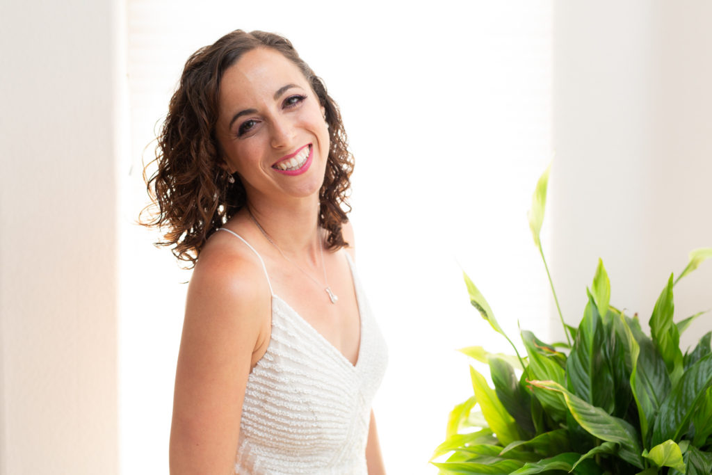 bridal portrait with Dallas wedding photographer capturing bride in a lace wedding dress in her bridal suite with a green plant in the distance