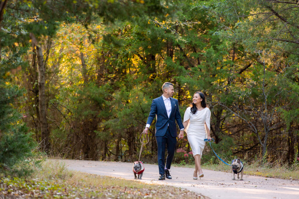 Couple Photos With Dogs walking down a tree-lined path in Arbor Nature Preserve
