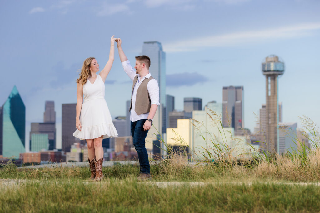 Dallas wedding photographers capture couple during outdoor engagement session man spinning woman