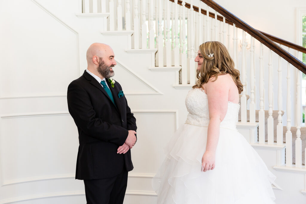 Groom smiling widely as he sees his bride for the first time during first look at wedding at milestone denton in texas