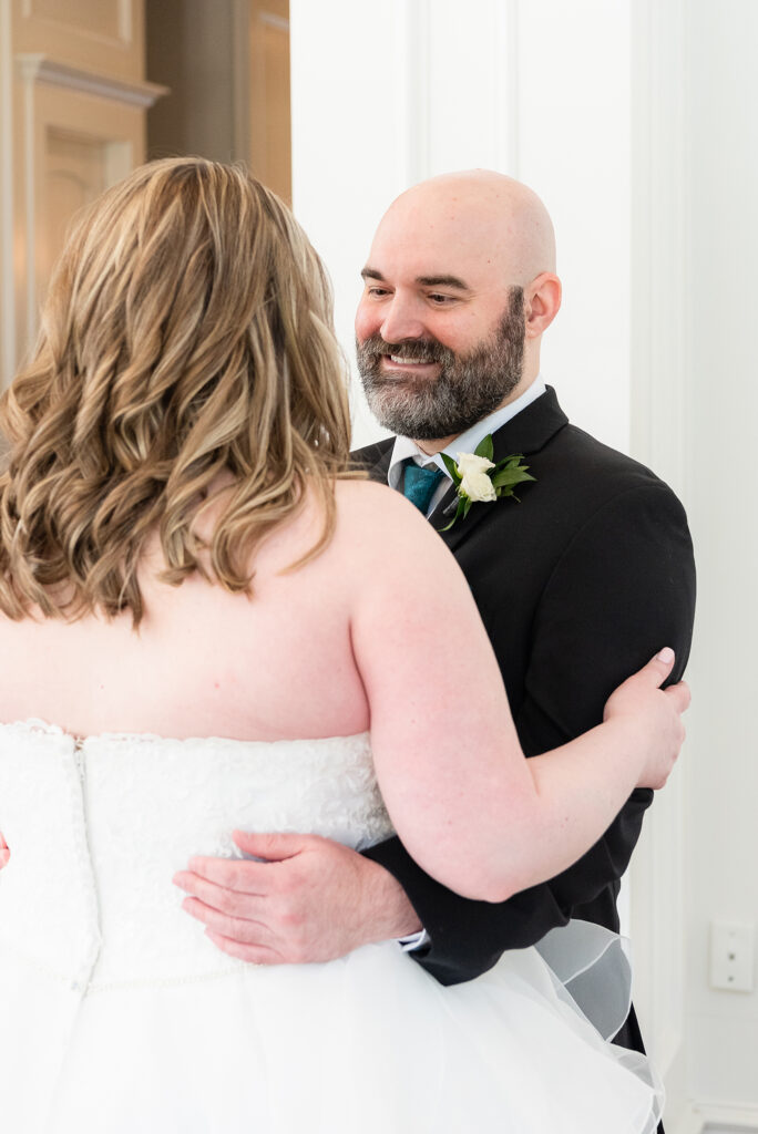 Groom smiling at bride during first look at Milestone wedding venue in Denton TX