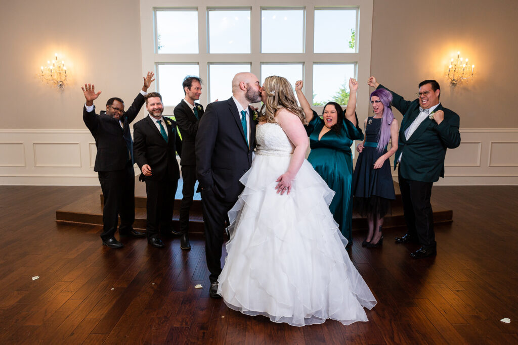 Bride and groom kiss while wedding party celebrates in chapel at Milestone wedding venue in Denton Texas by dallas wedding photographer Stefani Ciotti Photography