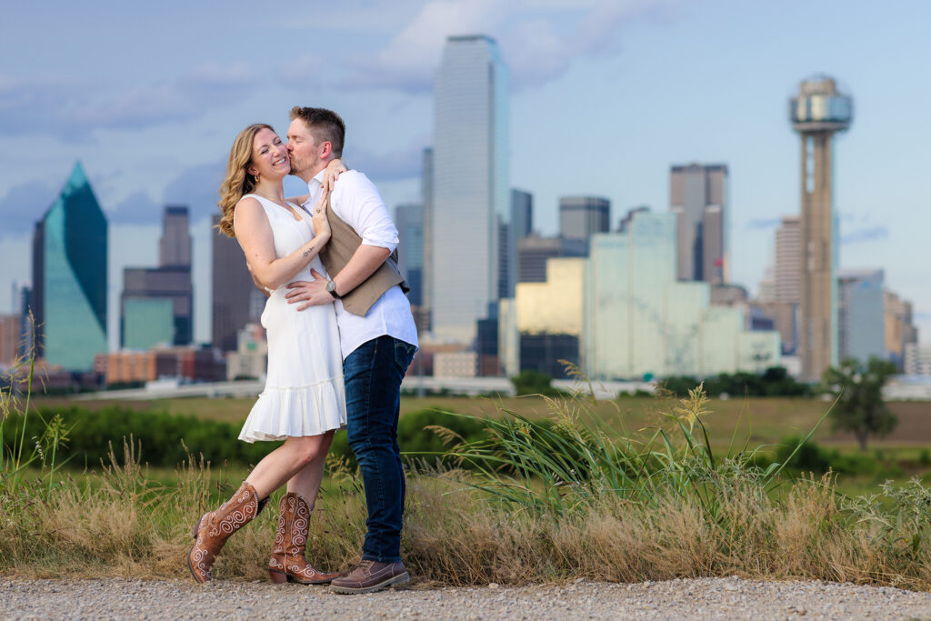 Dallas wedding photographers capture couple dipping during engagement session at Dallas skyline