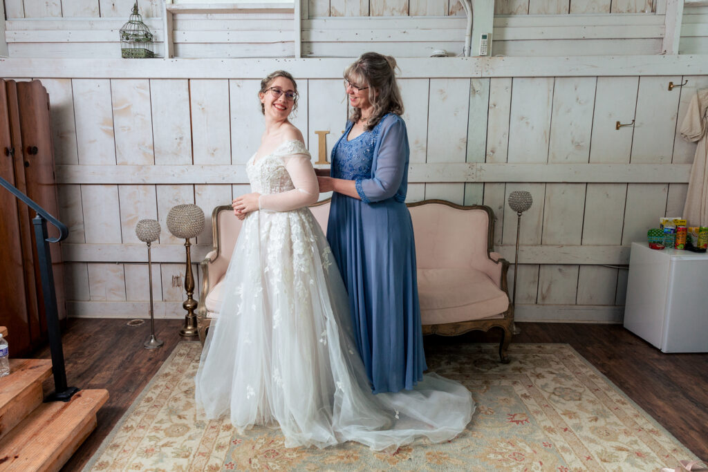 Dallas wedding photographers capture mother helping bride getting wedding dress on 