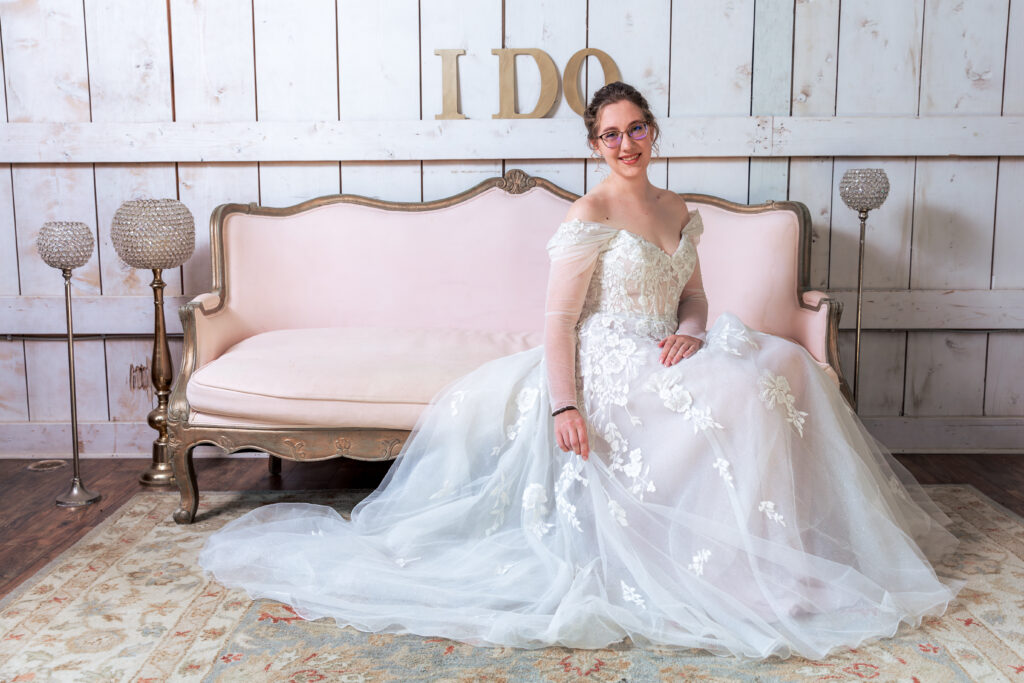 Dallas wedding photographers capture bride sitting on pink couch wearing bridal gown