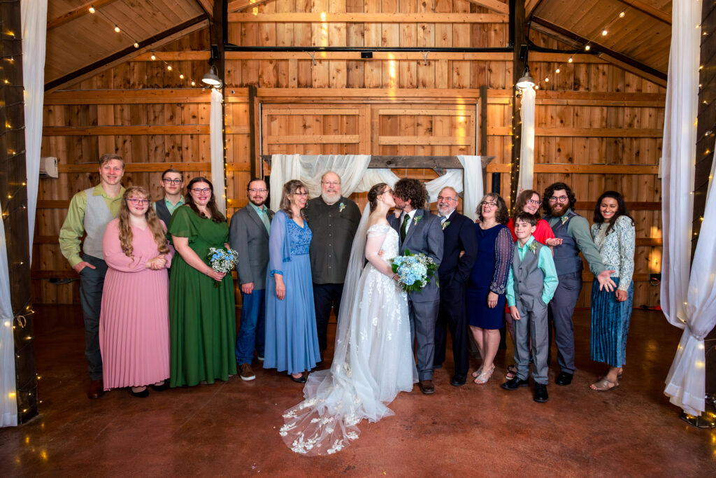 Dallas wedding photographers capture bride and groom standing with family 
