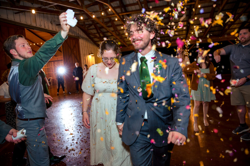 Dallas wedding photographers capture newly married couple walking out during confetti exit at the Big White Barn