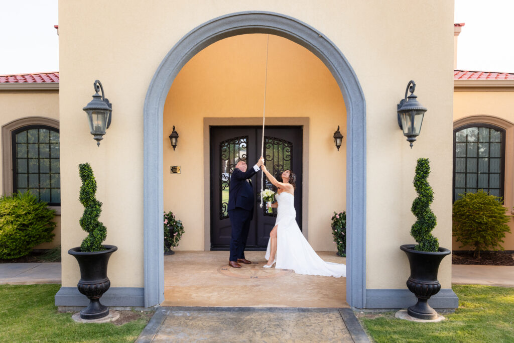 Dallas wedding photographer captures bride and groom ringing bell at Stoney Ridge Villa before grand entrance