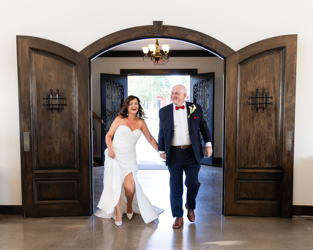 Dallas wedding photographer captures bride and groom walking into reception hall at stoney ridge villa