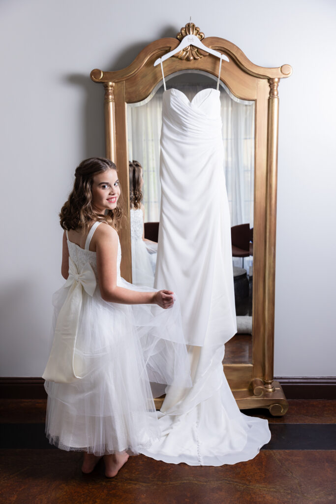 Dallas wedding photographer Stefani Ciotti Photography captures sweet granddaughter with wedding dress hanging on mirror in Stoney Ridge Villa's bridal suite