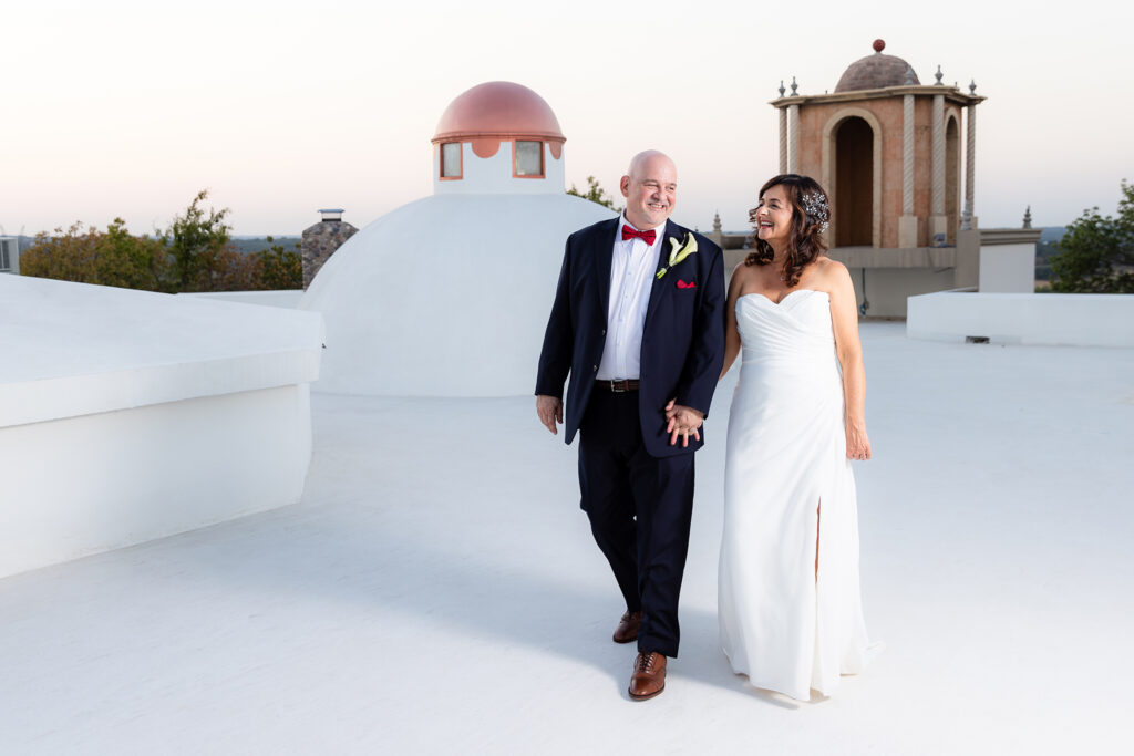 Bride and groom laughing and walking hand in hand on Stoney Ridge Villa rooftop captured by Stefani Ciotti Photography