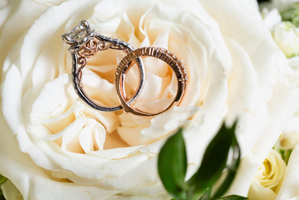 Platinum and rose gold intricate wedding and engagement ring design on white rose